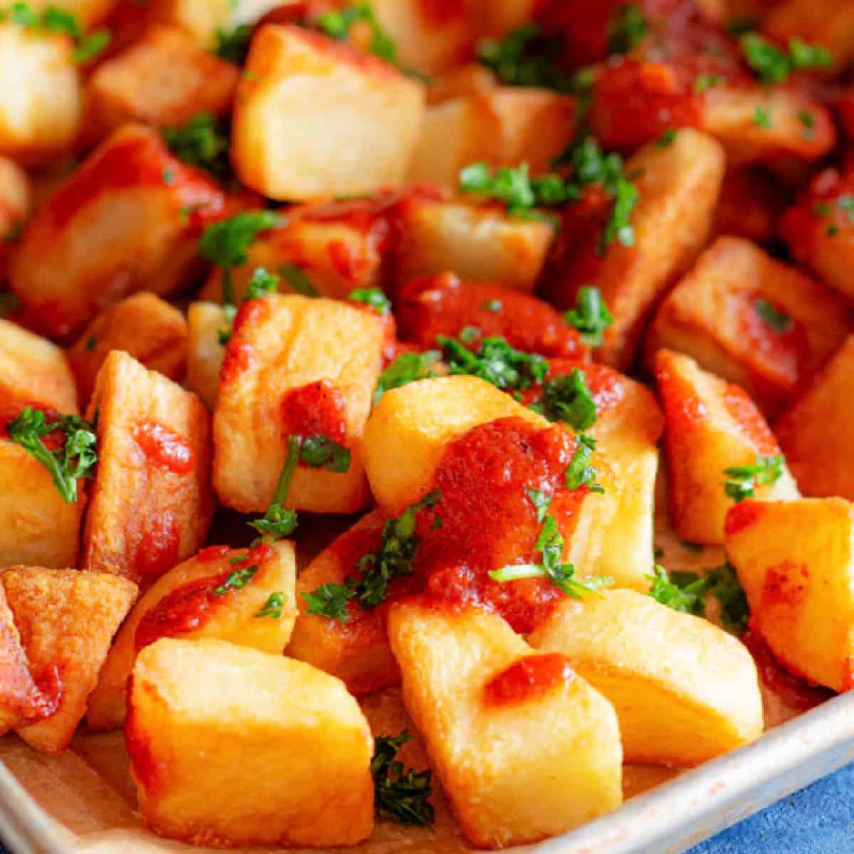 Patatas bravas is a classic Spanish tapas dish. Crispy potatoes topped with spicy tomato sauce and garlic aioli makes a simple but tasty recipe!