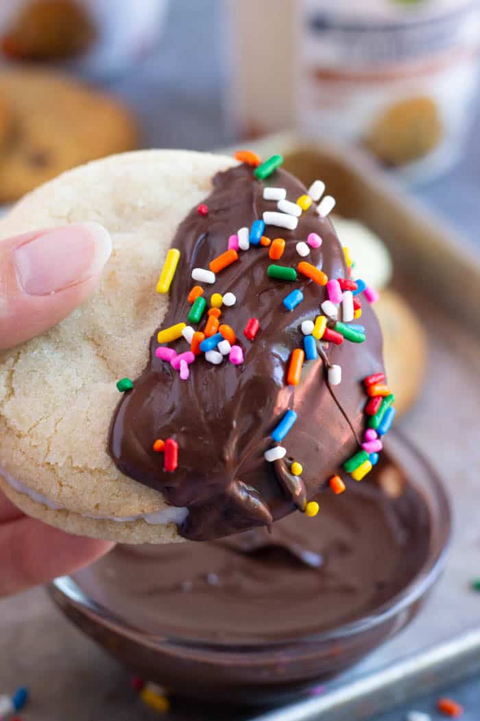 Dip the ice cream sandwich in melted chocolate and top with sprinkles. 