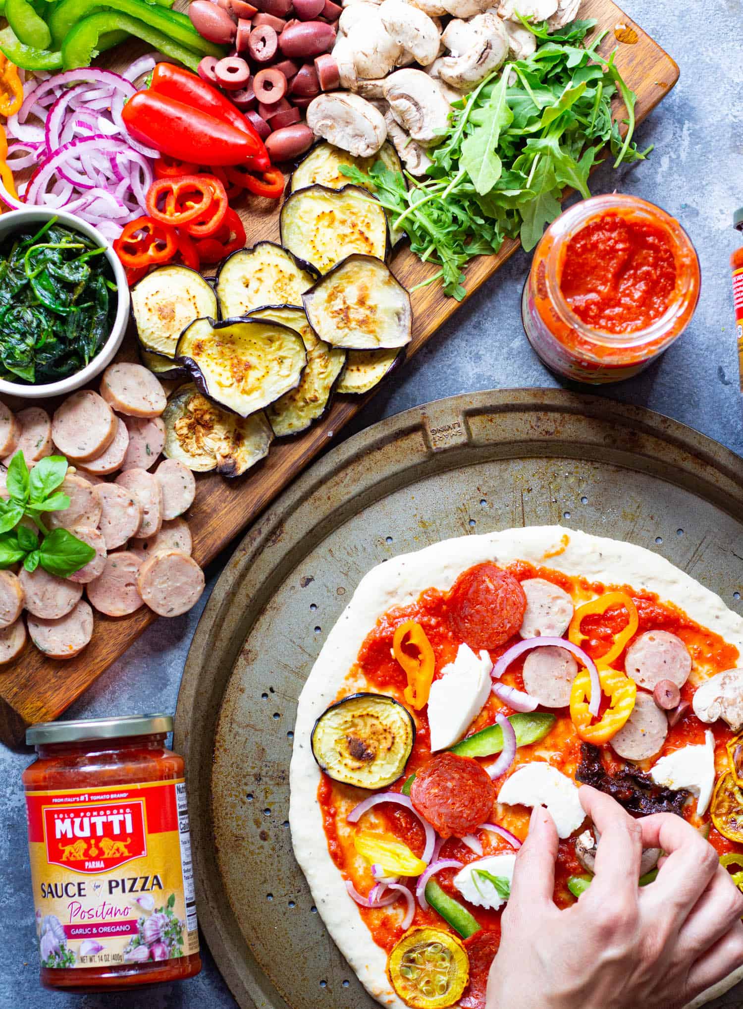 Spread pizza sauce on the dough and top it with your favorite toppings including vegetables and sausage or pepperoni. 