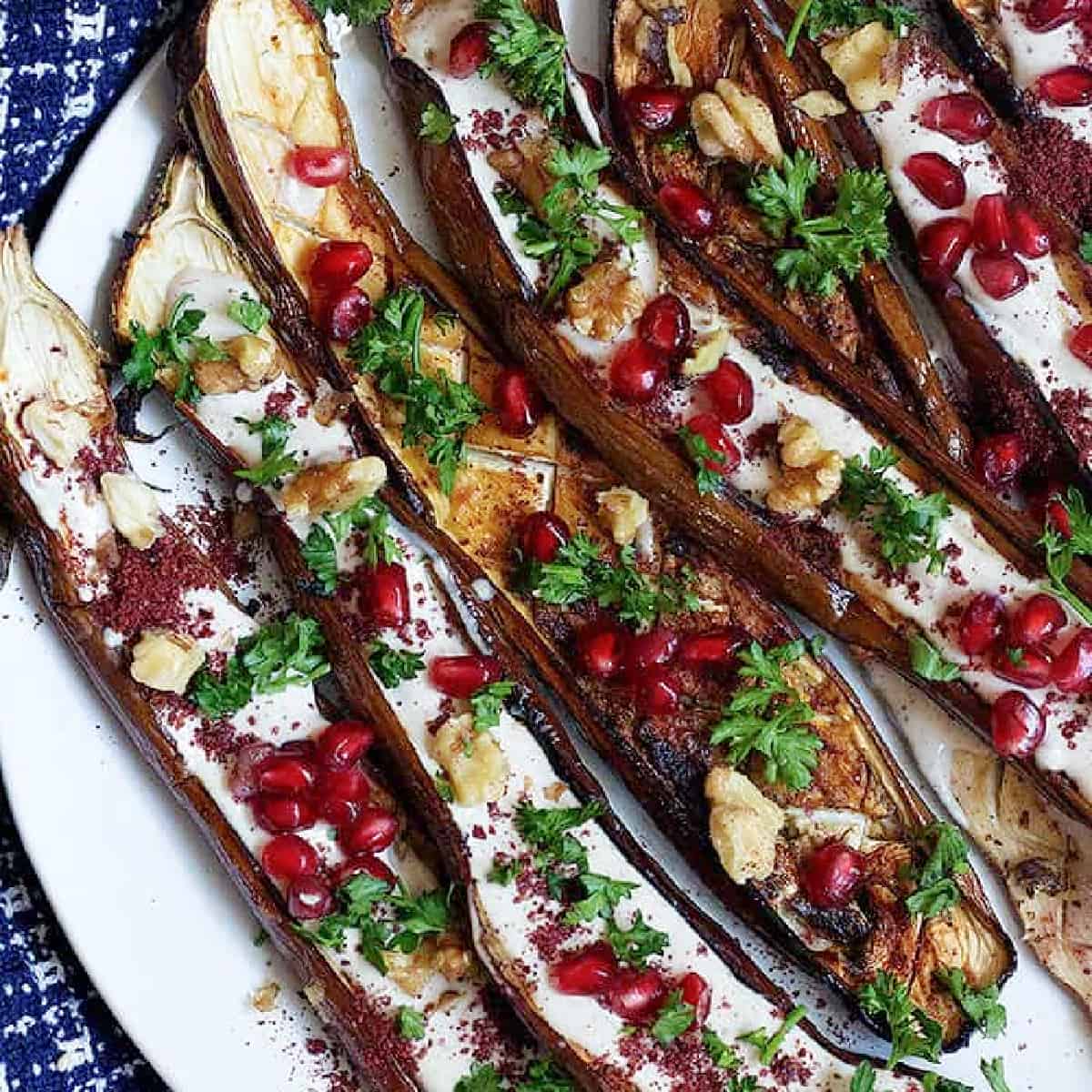 This is a great Middle Eastern eggplant recipe to always keep on hand. Perfectly roasted eggplant is served with a stunning tahini yogurt sauce and pomegranate arils. It's perfect as a side dish or an impressive appetizer!
