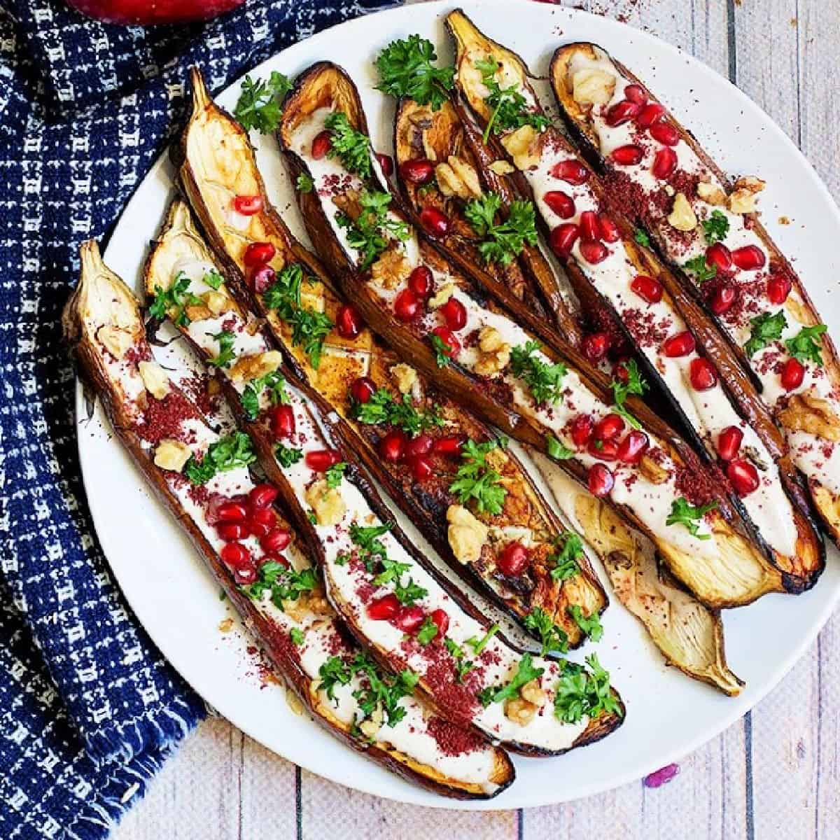 This is a great Middle Eastern eggplant recipe to always keep on hand. Perfectly roasted eggplant is served with a stunning tahini yogurt sauce and pomegranate arils. It's perfect as a side dish or an impressive appetizer!