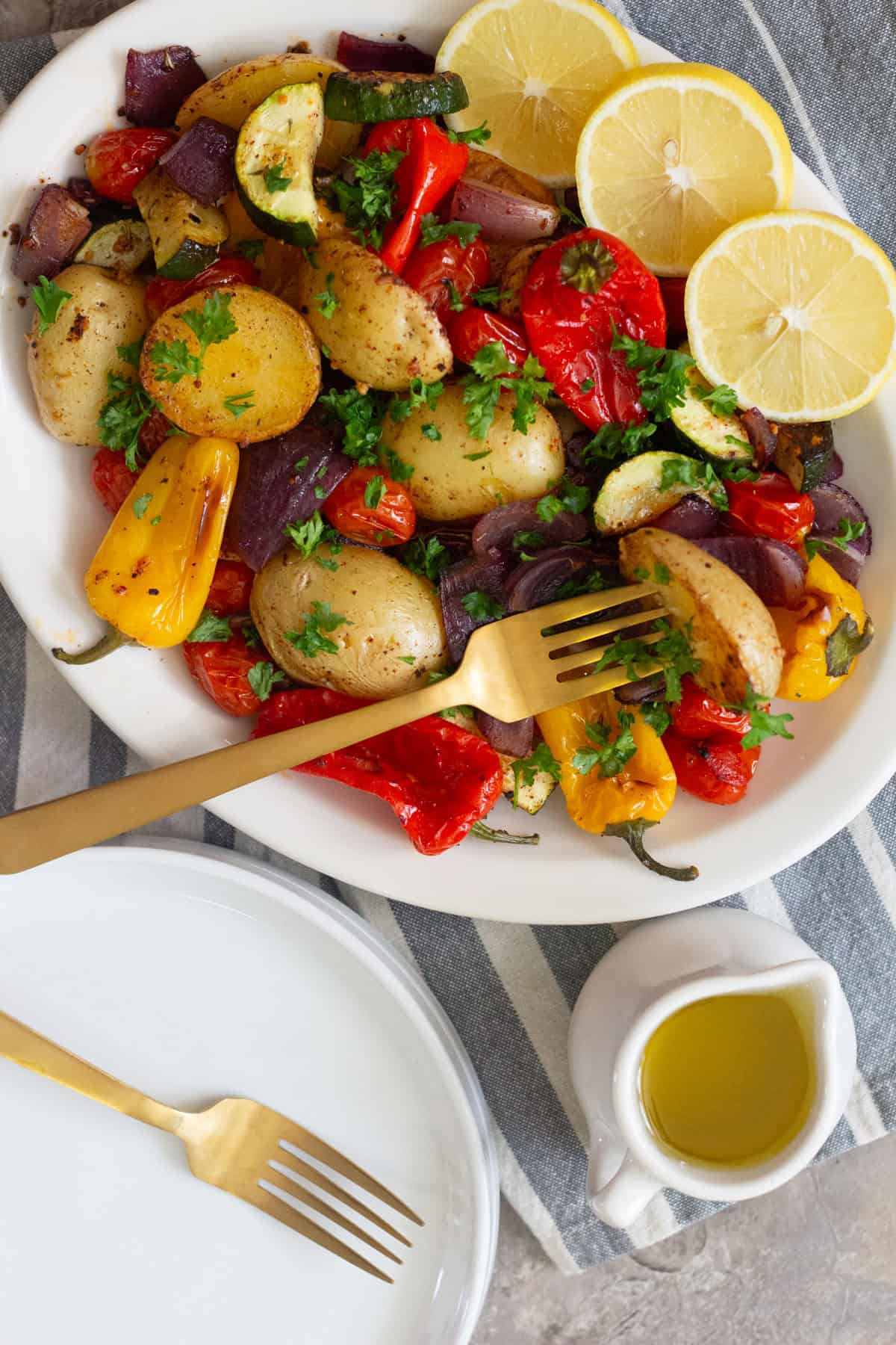 A platter of roasted vegetables with some olive oil. 