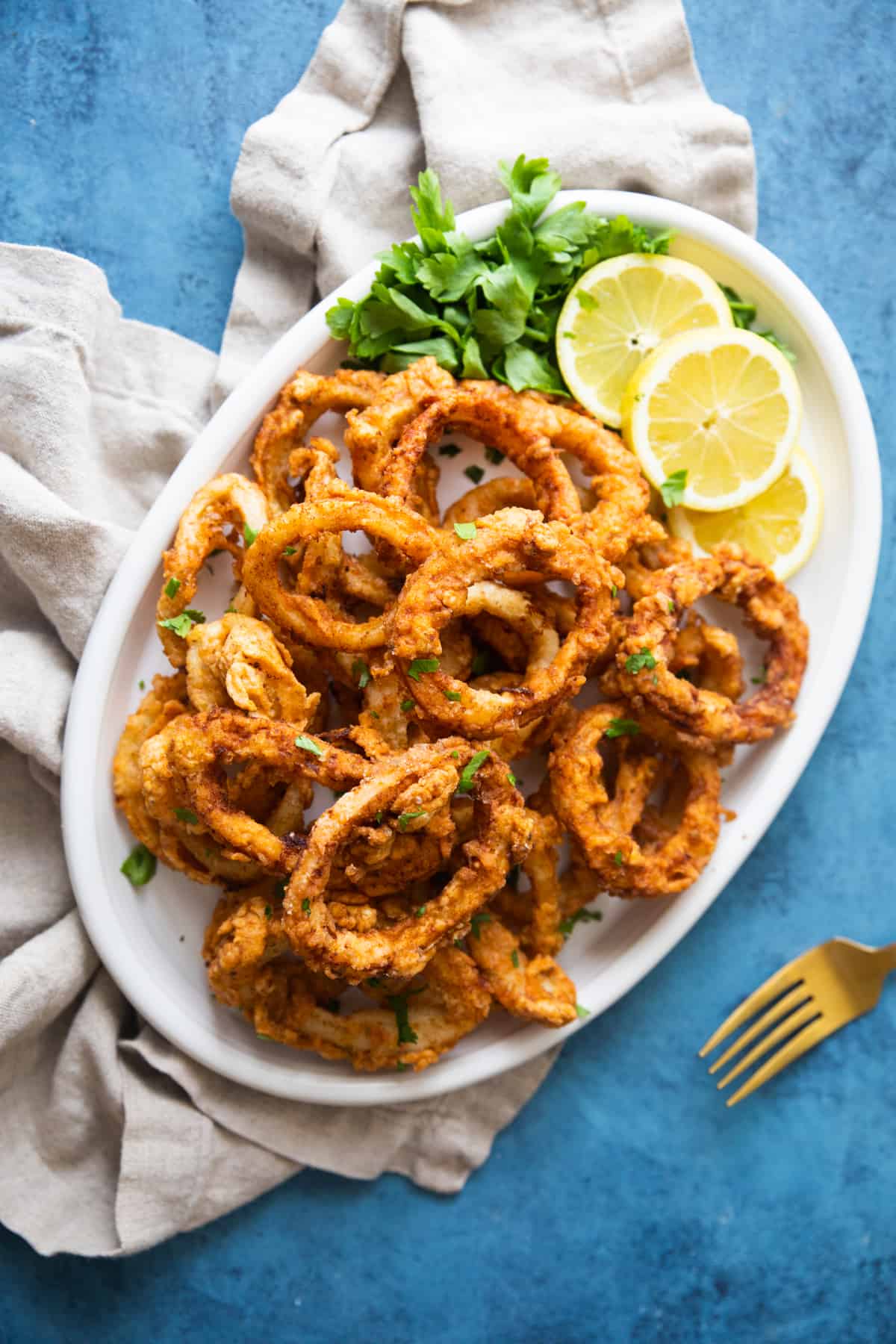 This easy fried calamari recipe will be your favorite. Calamari rings are soaked in milk to tenderize, coated in spiced flour and fried until crispy on the outside and tender on the inside. Perfection in every bite! 