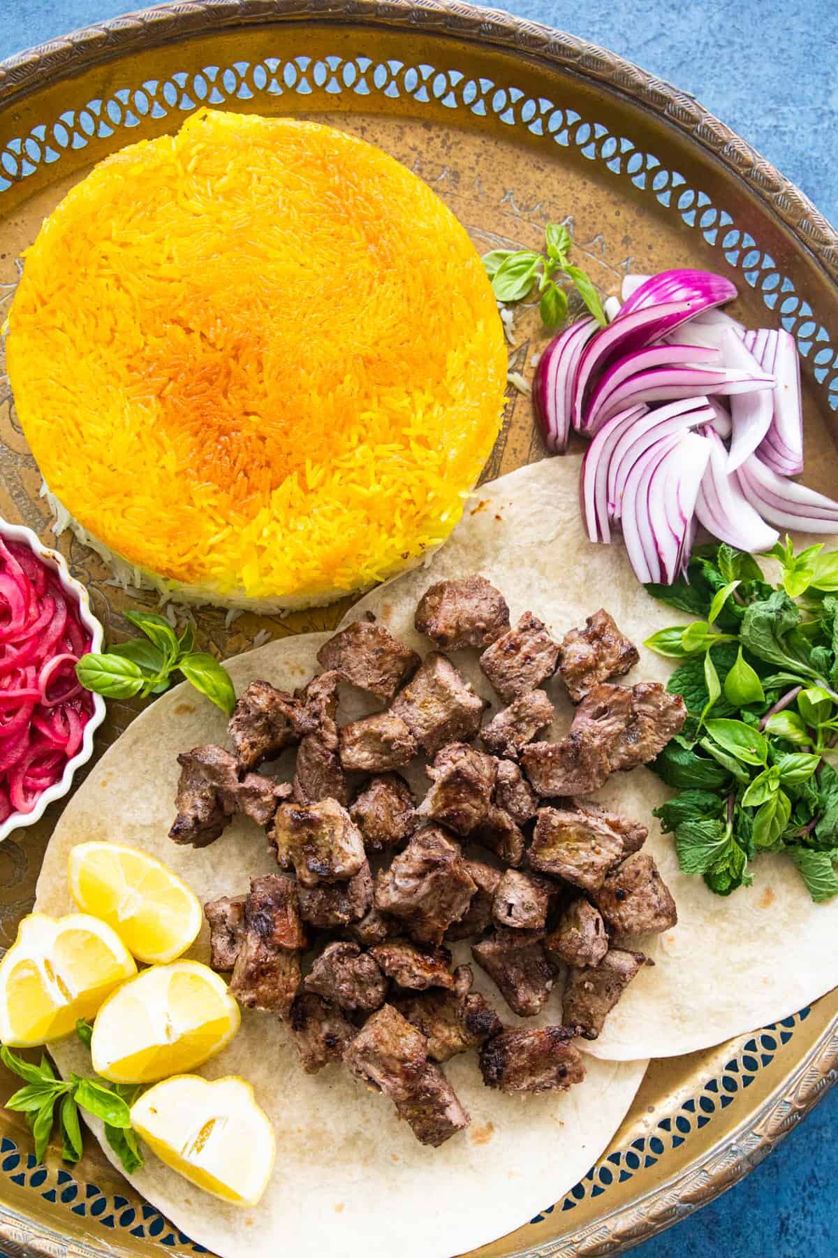 Pieces of ribeye kebab on lavash with saffron rice. 