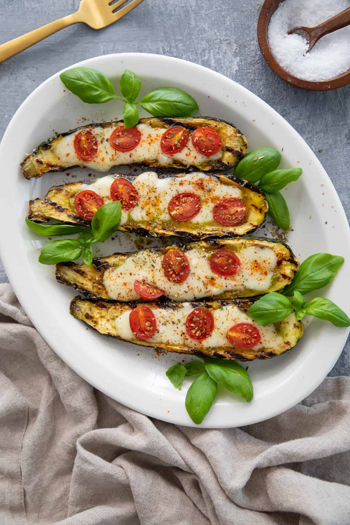 Grilled caprese stuffed zucchini boats are easy and delicious. Learn to fill zucchinis with pesto, cheese and tomatoes to make the perfect dish.
