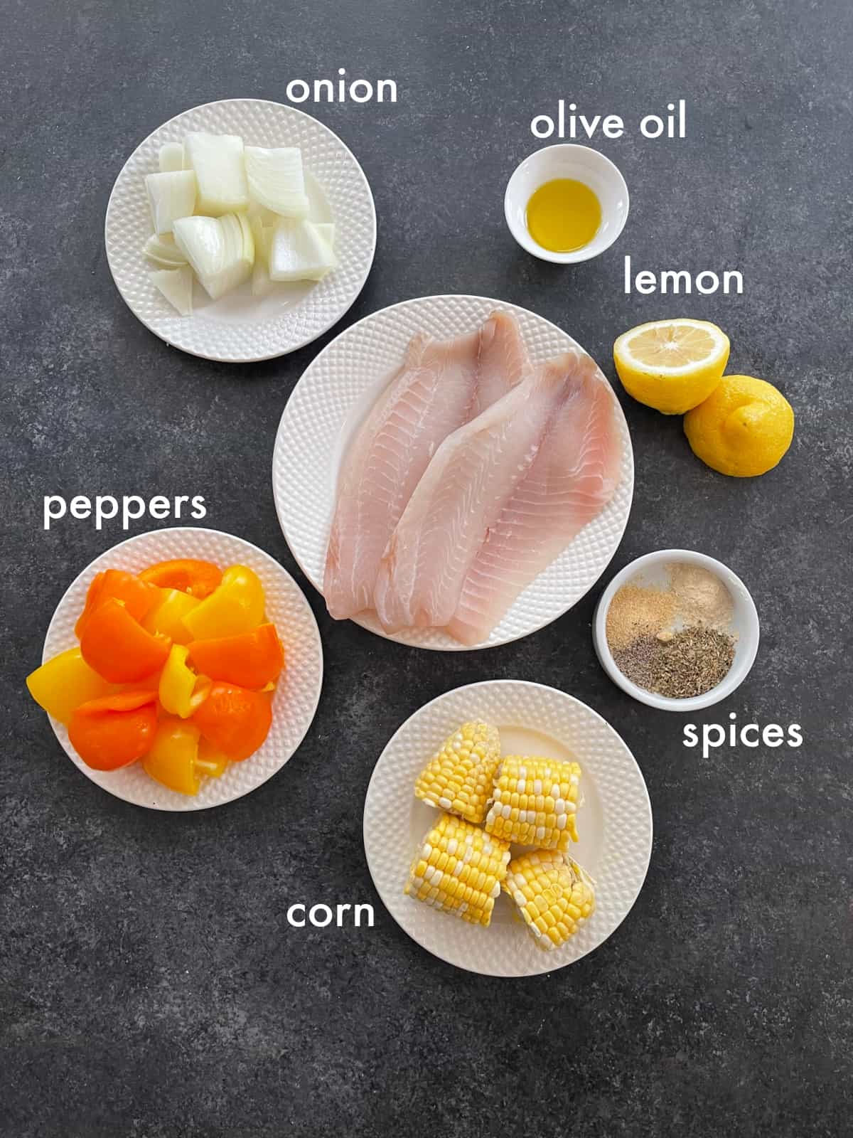 To make this recipe you need tilapia, peppers, onions, lemon, corn and spices. 