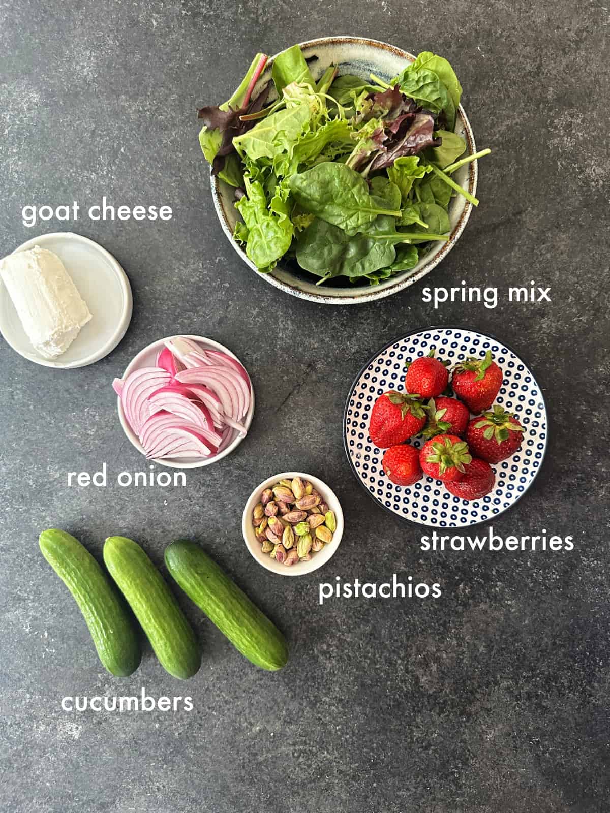 To make this salad you need spring mix, strawberryes, red onion, cucumbers, goat cheese and pistachios.