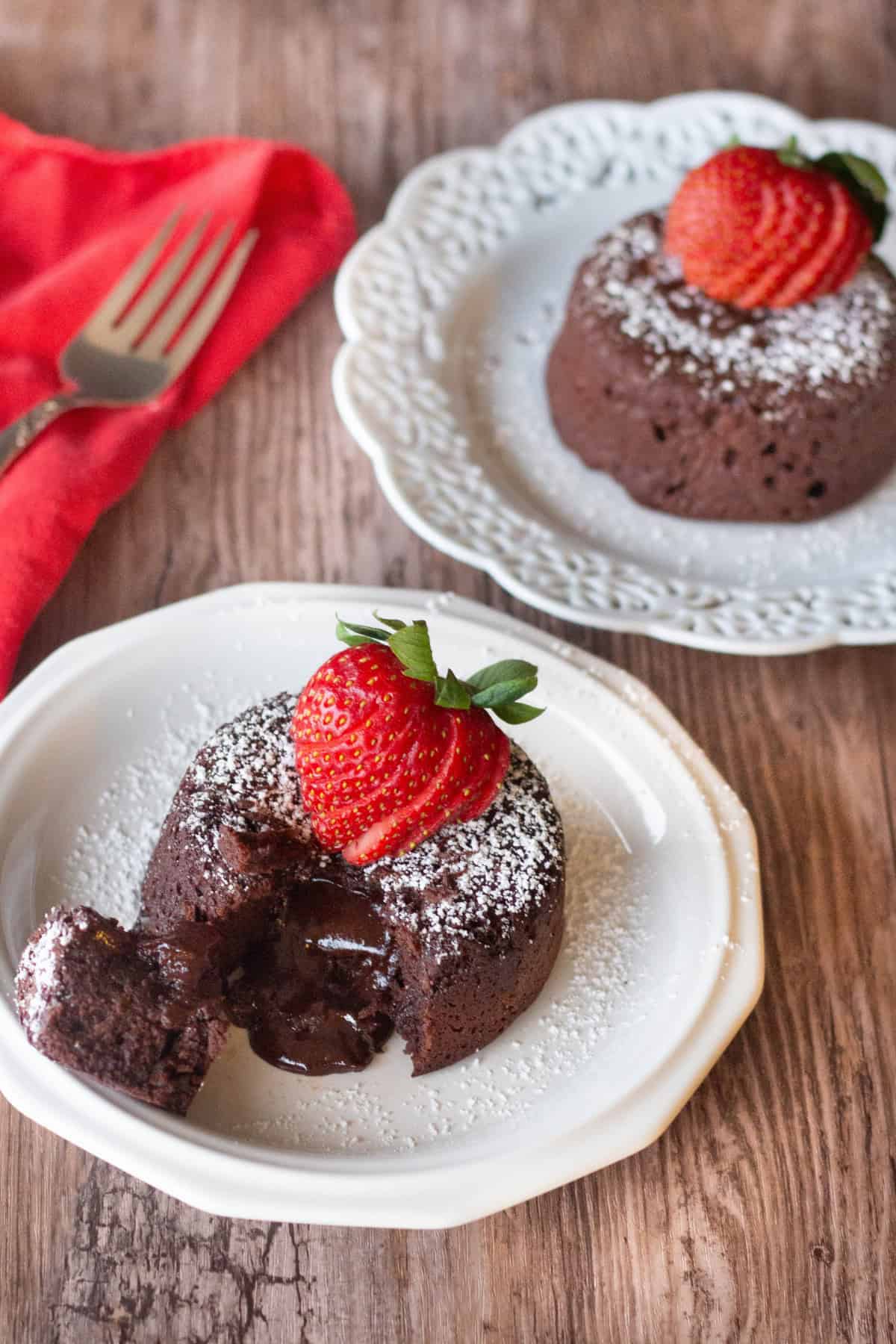 Molten chocolate cake topped with powdered sugar and a strawberry. 