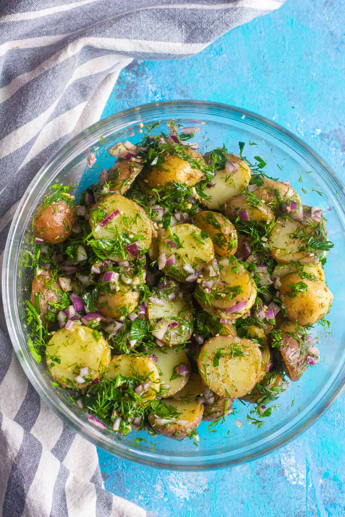 healthy mediterranean style potato salad in a glass bowl. 