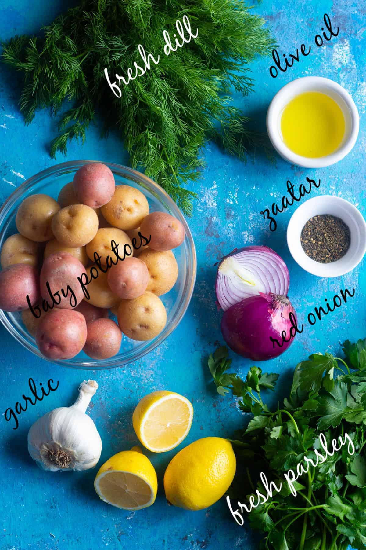 Ingredients to make Mediterranean potato salad: potatoes, dill, parsley, red onion, garlic, zaatar, olive oil and lemon juice