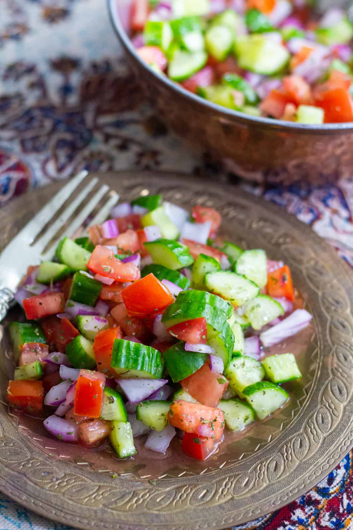 Persian salad shirazi served on a plate with a fork on the side.