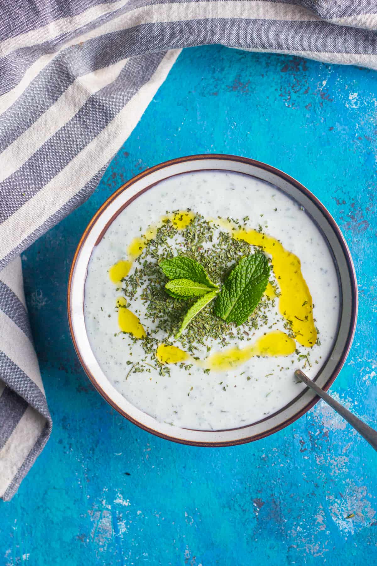 cacik in a bowl with dried mint fresh mint and olive oil 