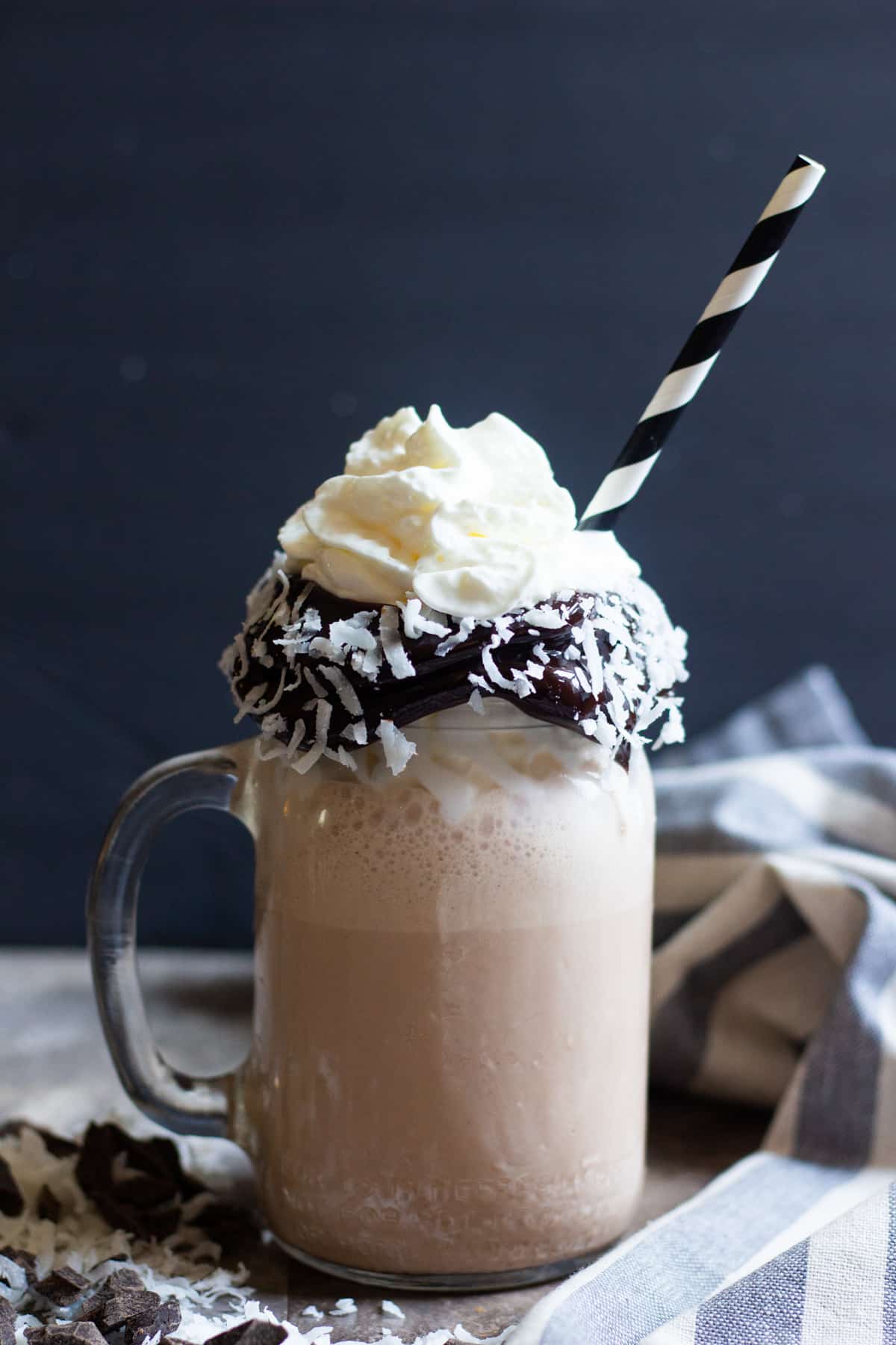 Delicious coconut milkshake poured into a glass topped with whipped cream. 