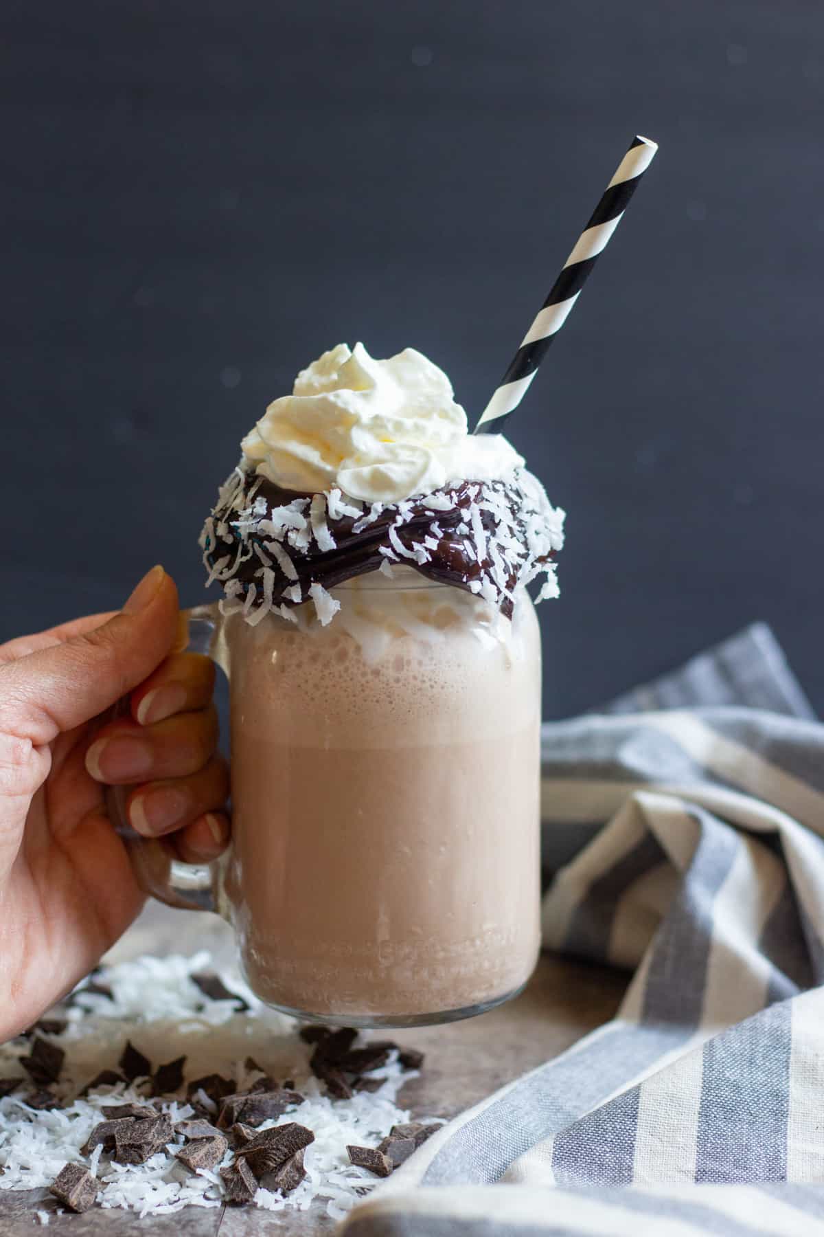 This easy milkshake recipe is perfect for summer especially in a glass that has a chocolate and coconut rim.