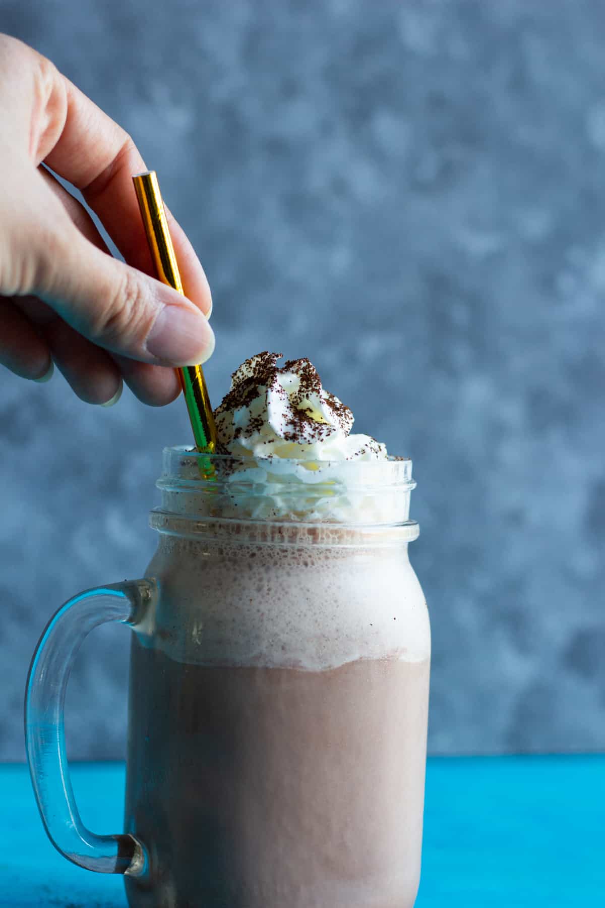 milkshake made with coffee in a glass with a golden straw