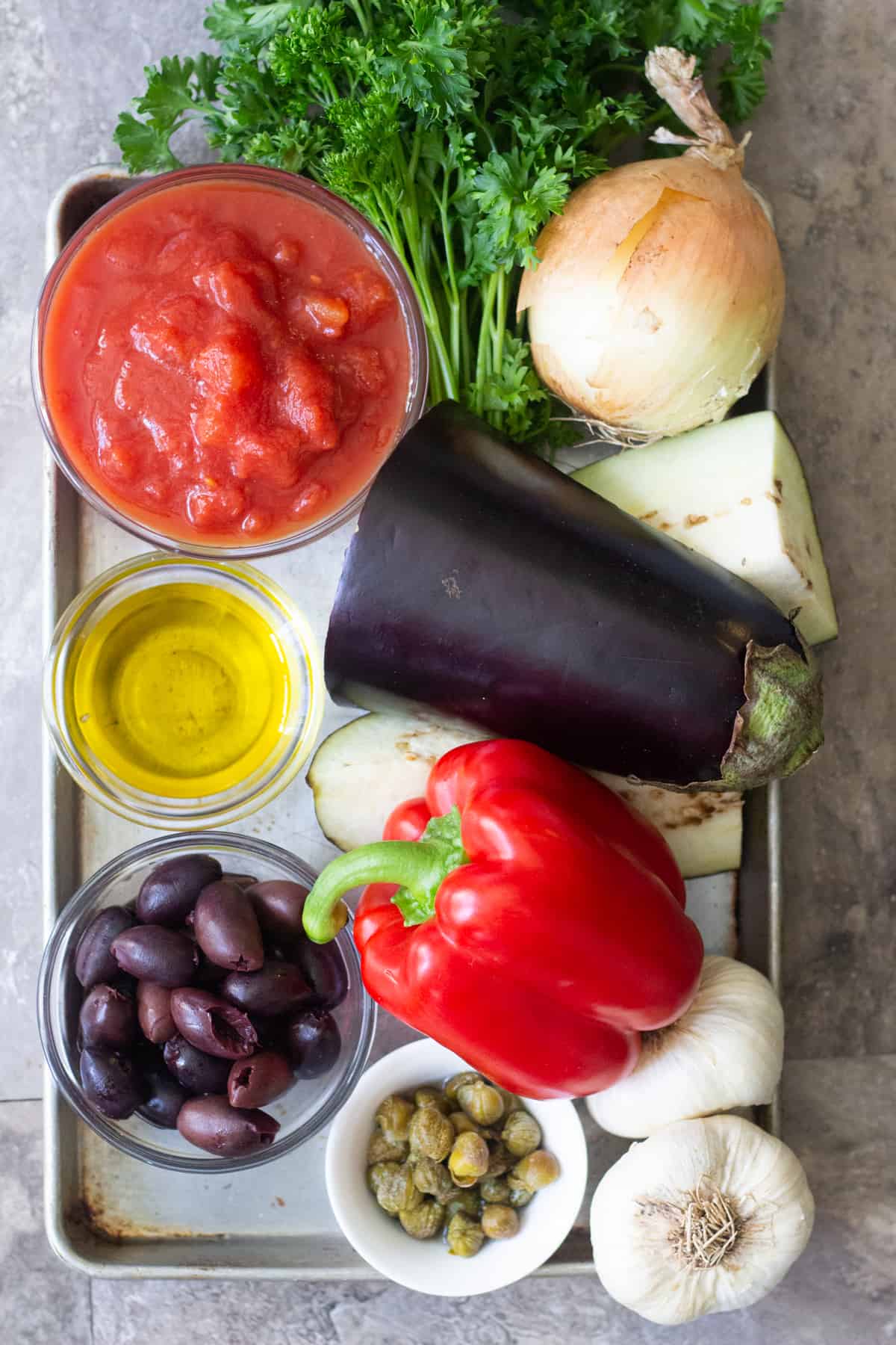 To make this easy eggplant dish, you need the following ingredients: Eggplants Onions Garlic Tomatoes Red bell pepper Olives Capers