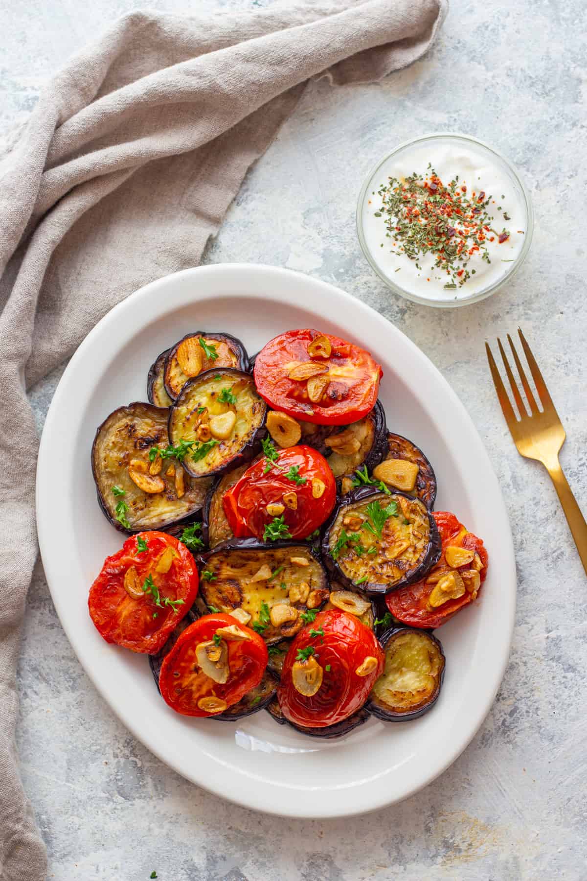Fried eggplant with tomatoes are the easiest side dish. Fresh eggplant and tomatoes fried to perfection and are topped with crispy garlic.