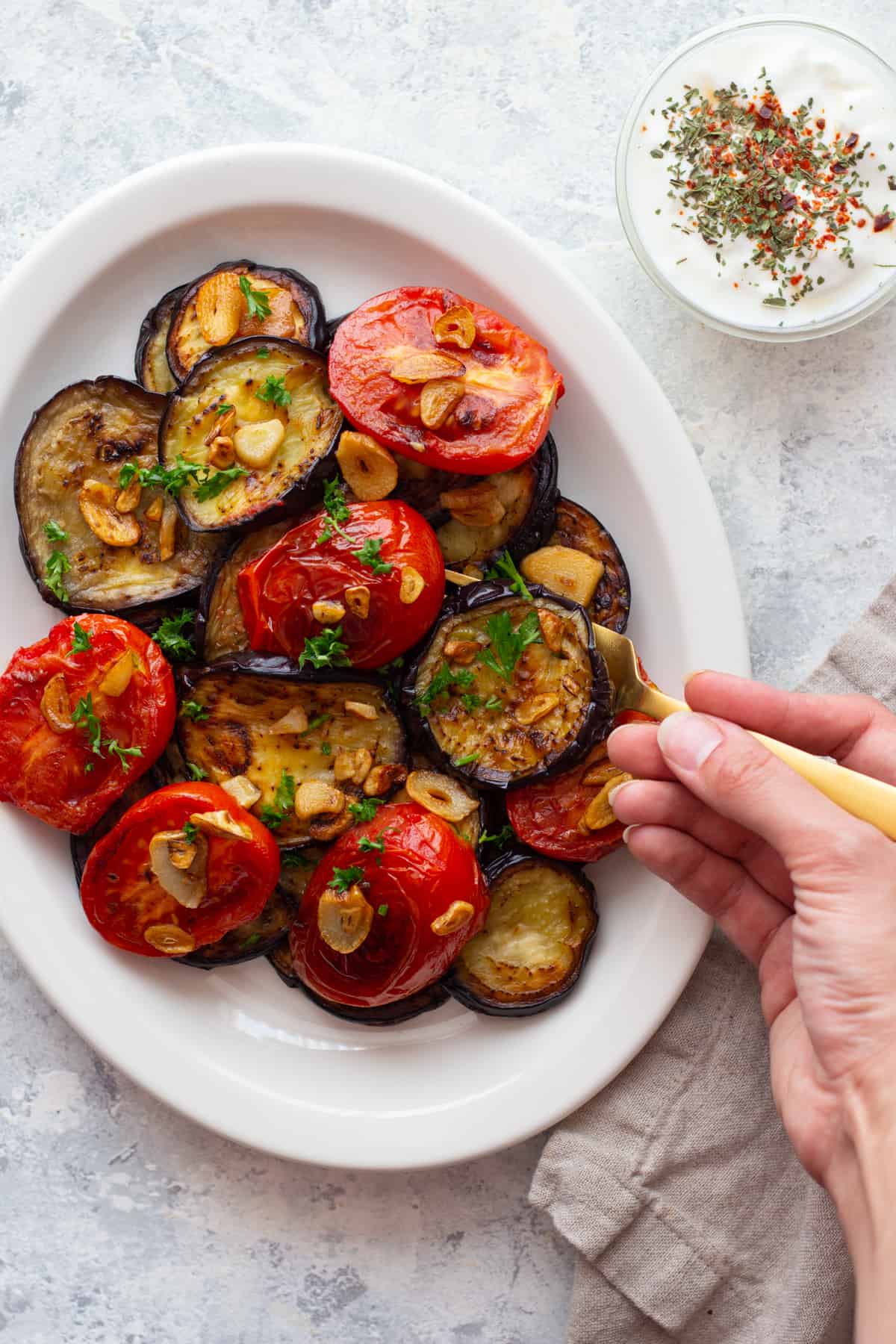 fried eggplants and tomatoes on a white platter. 