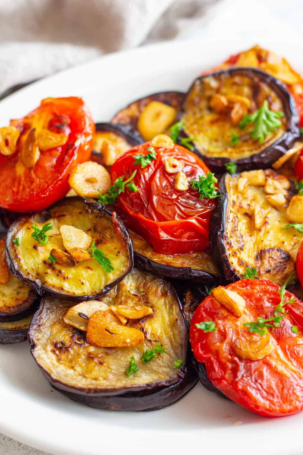 fried eggplant topped with tomatoes and garlic.