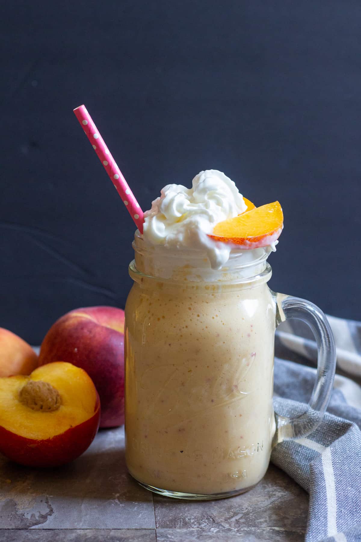 This easy milkshake recipe is perfect for kids and adults. Top with a slice of peach and drink with a straw. 