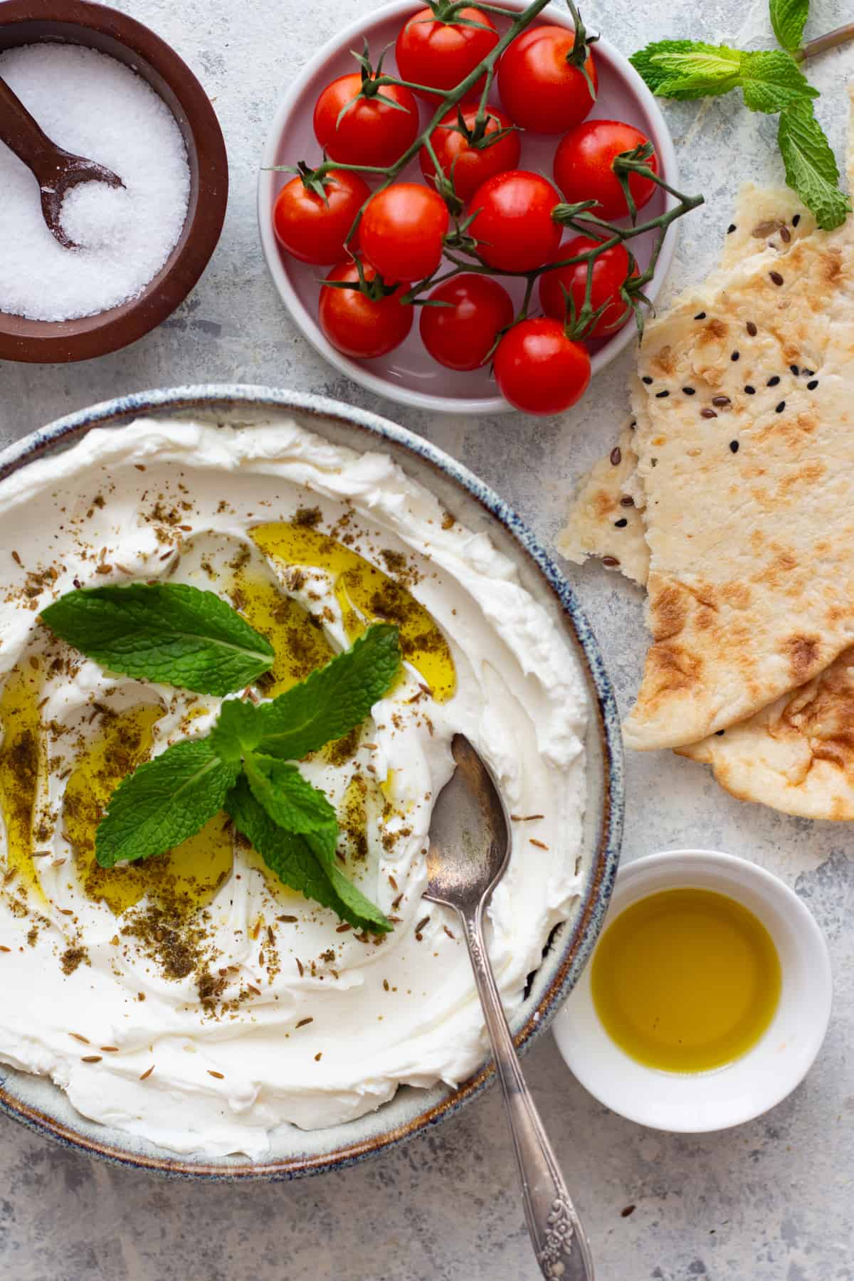 Labneh spread in a shallow bowl served with pita. 