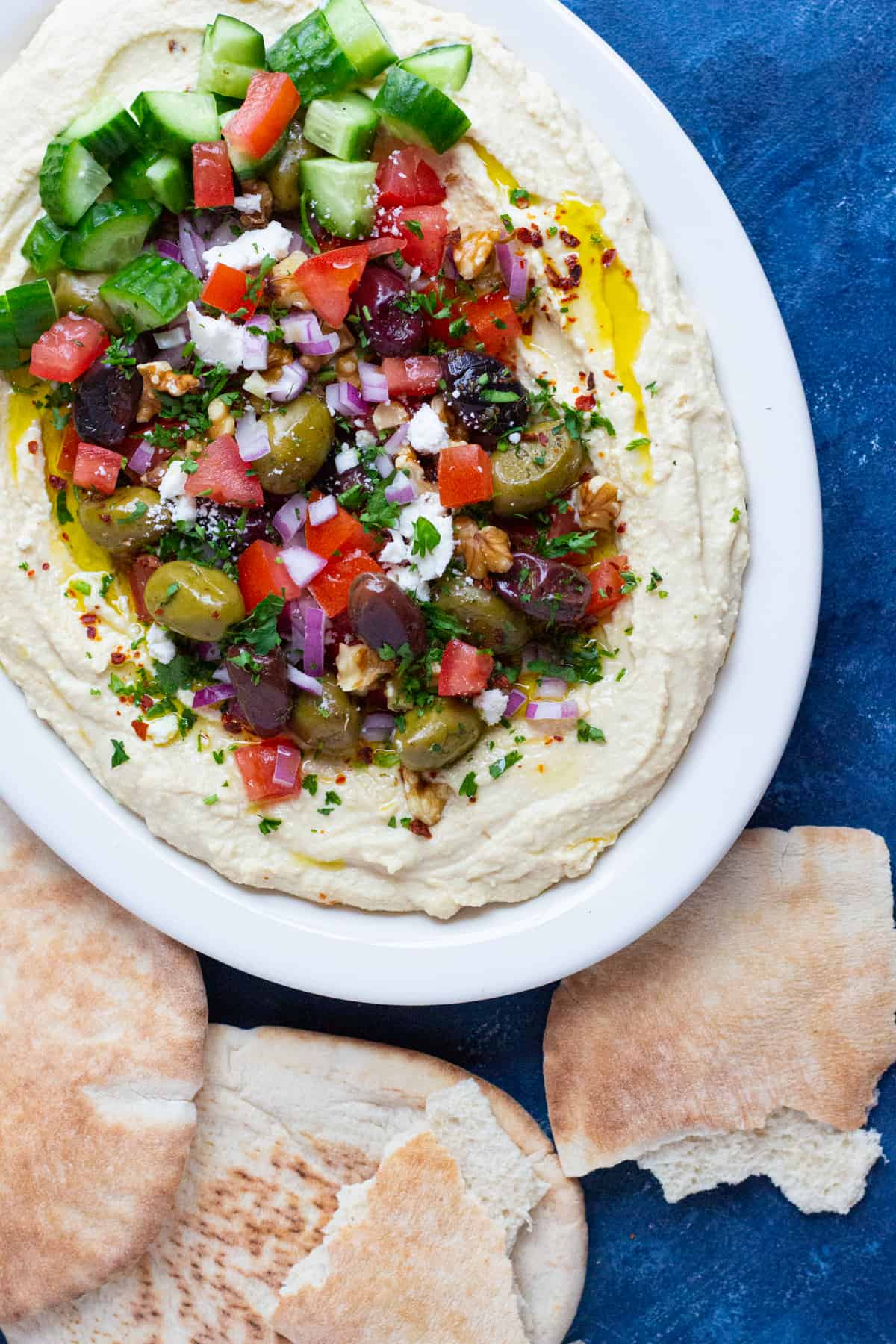 This loaded hummus recipe with all the fixings is ready in 15 minutes! Creamy hummus is topped with delicious toppings and served with pita!