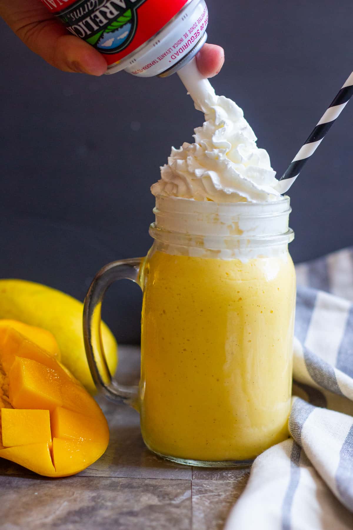 mango milkshake with ice cream is topped with whipped cream