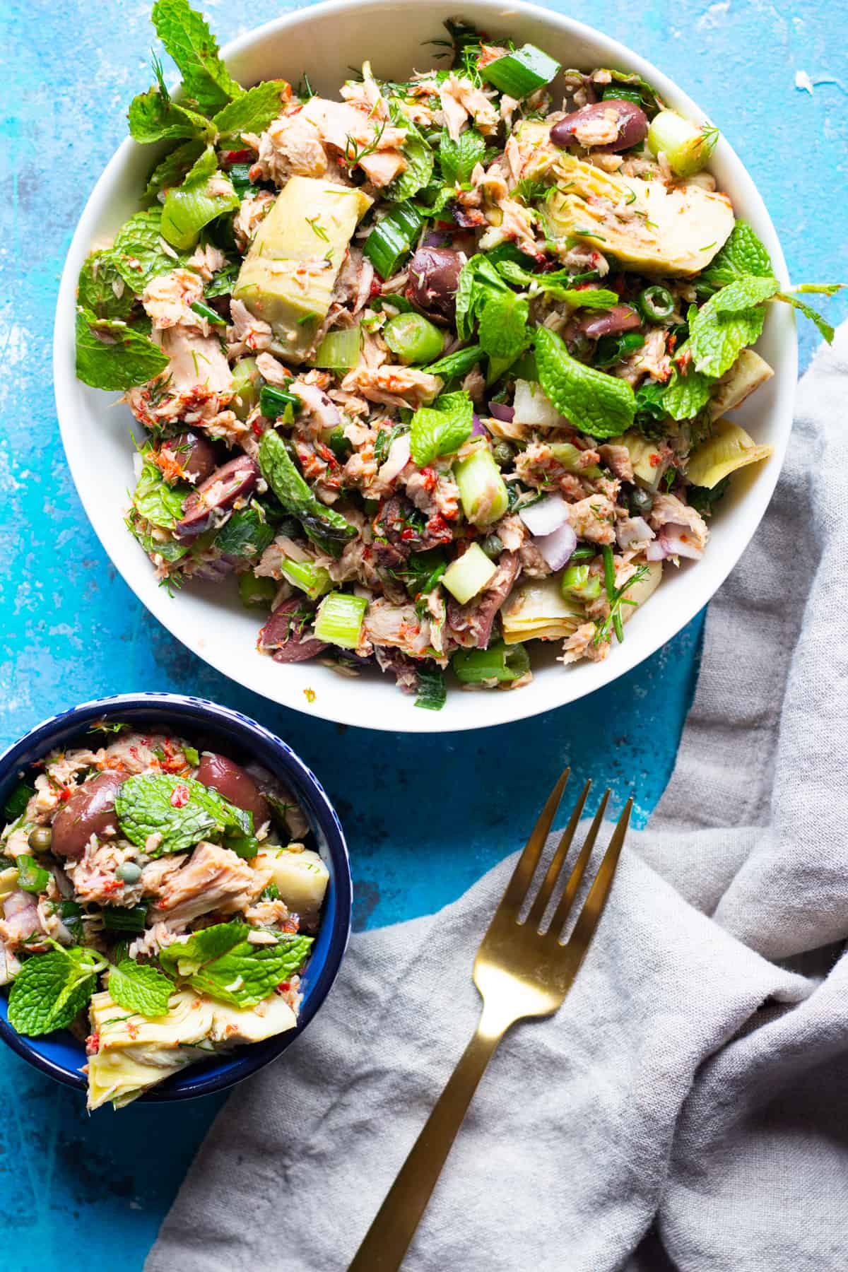 Two bowls of mayo free tuna salad on a blue surface. 