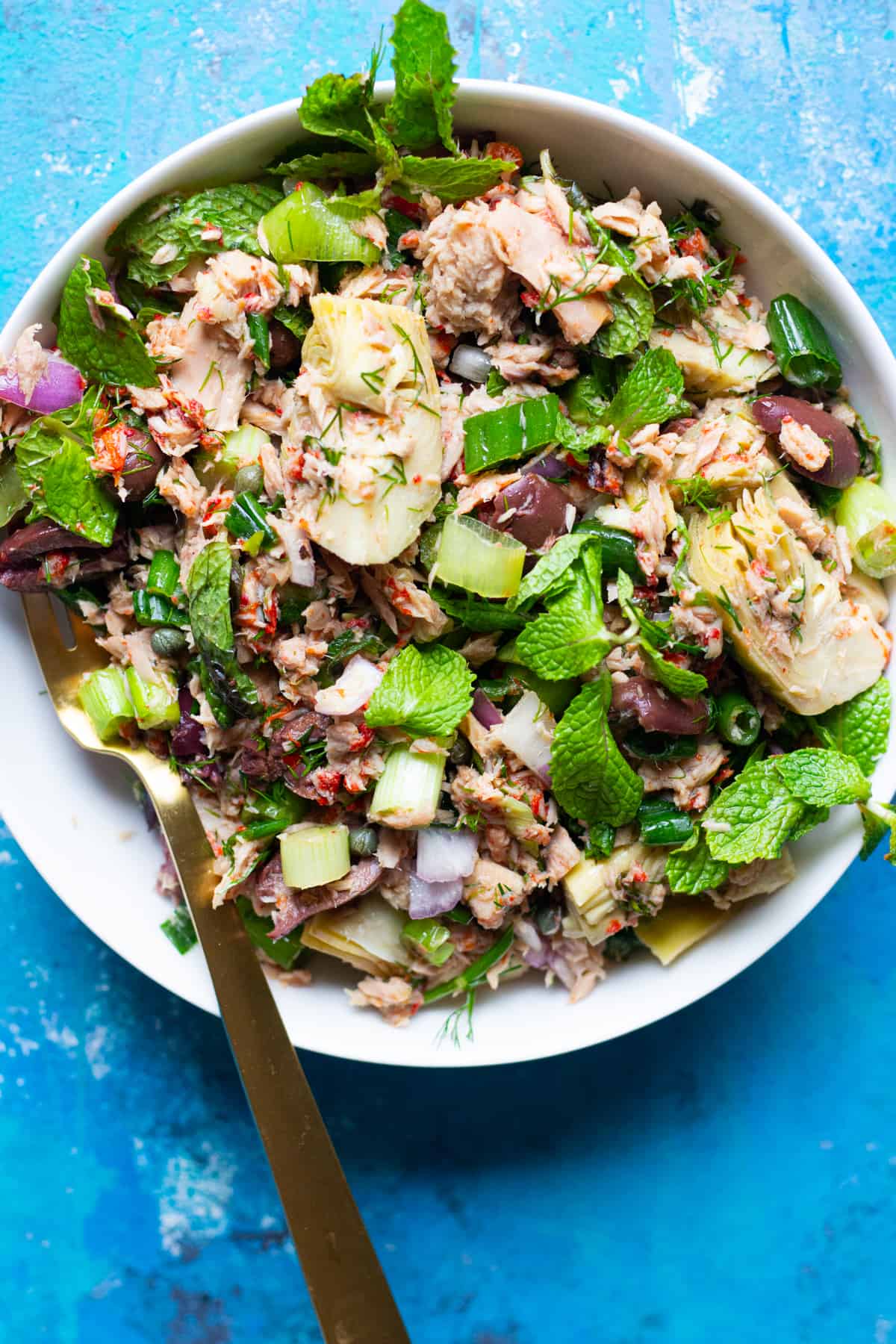 Mediterranean tuna salad in a bowl with herbs and artichoke