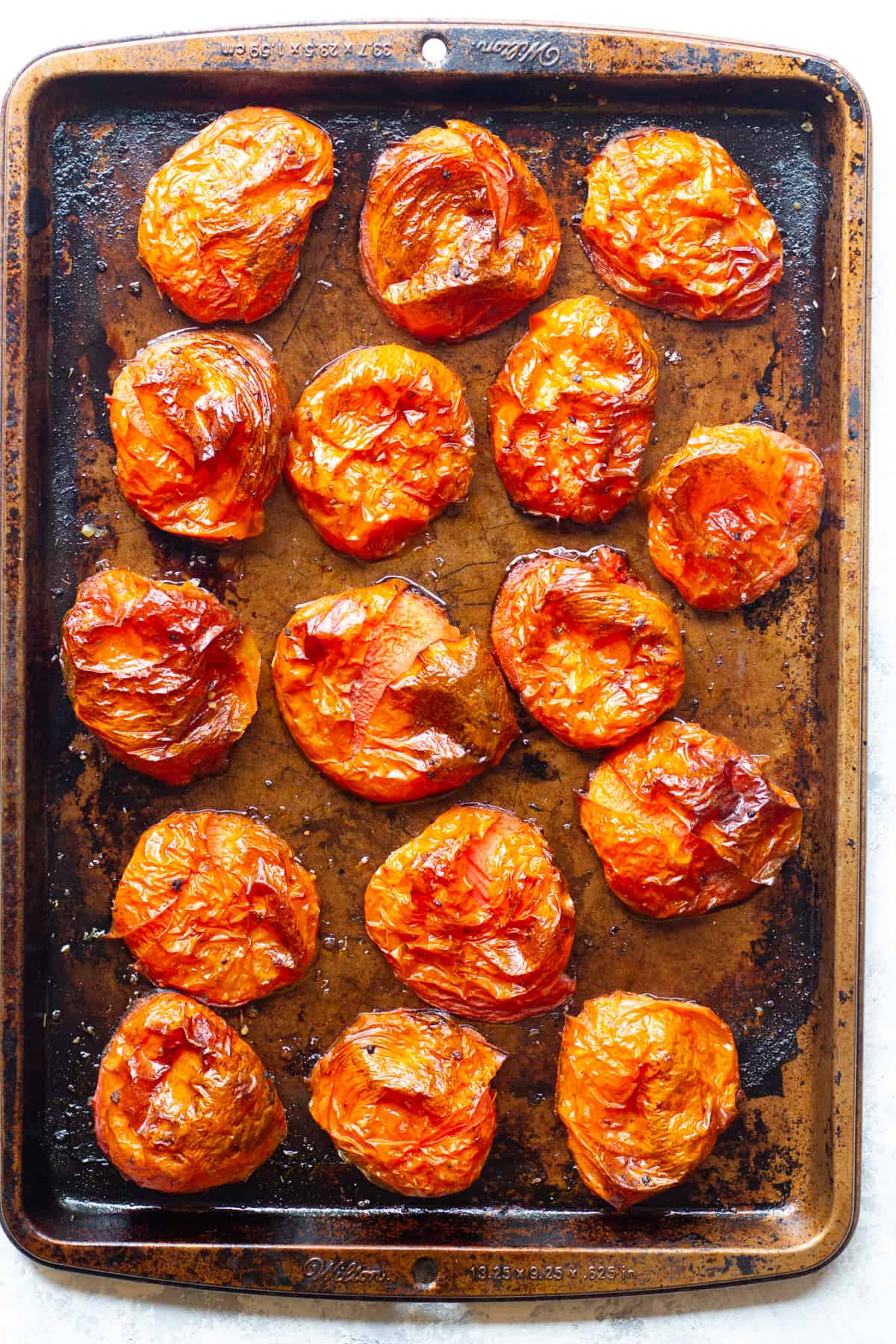 Oven roasted tomatoes on a baking sheet.