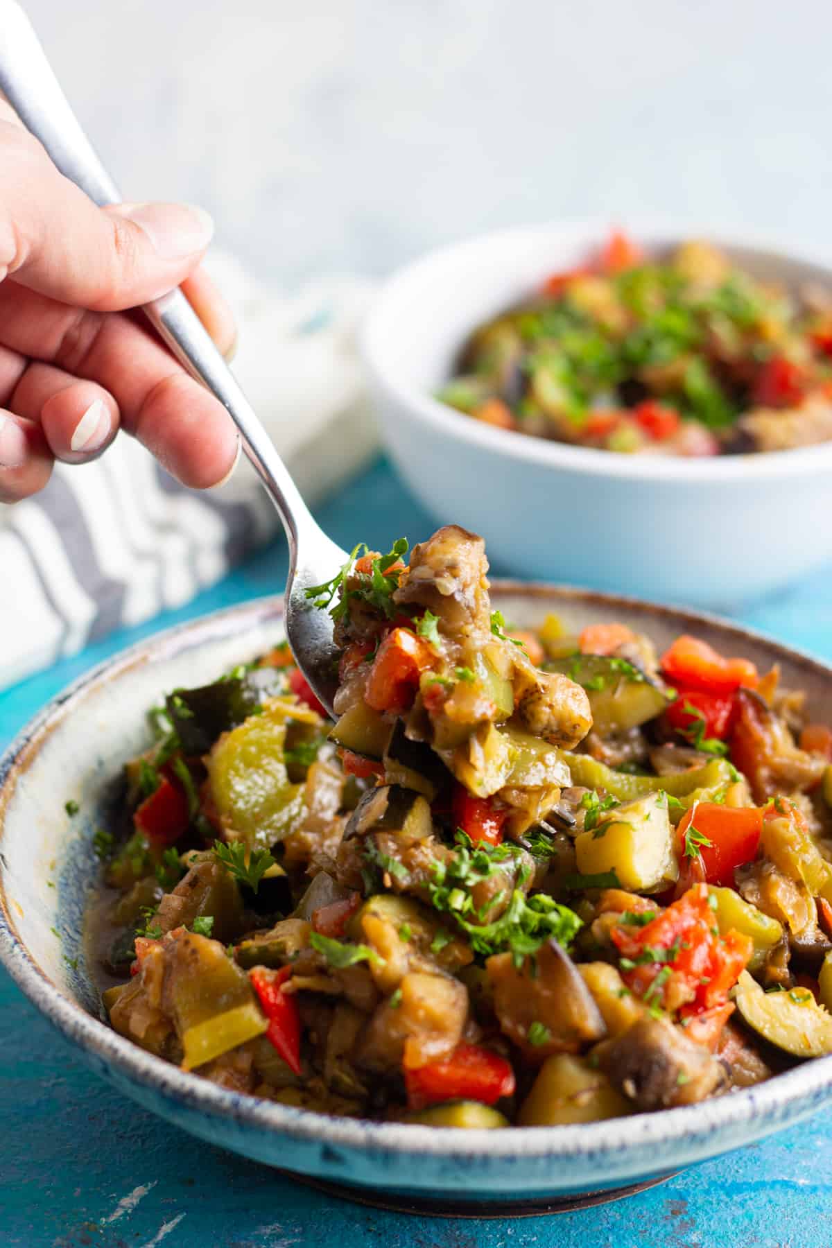 Mediterranean stew made with summer vegetables. Served in a bowl and with a fork. 