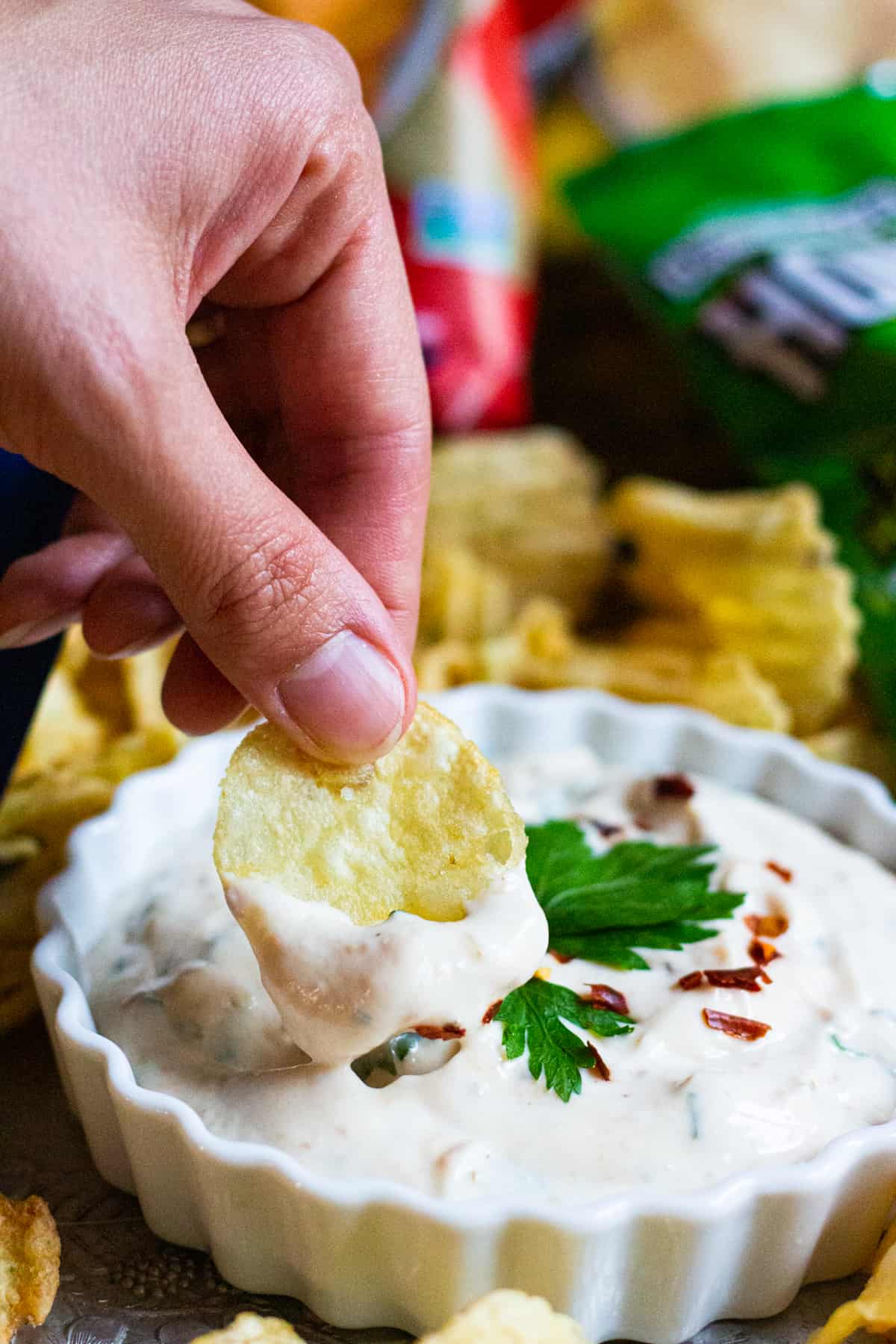 Chips being dipped in the roasted garlic dip.