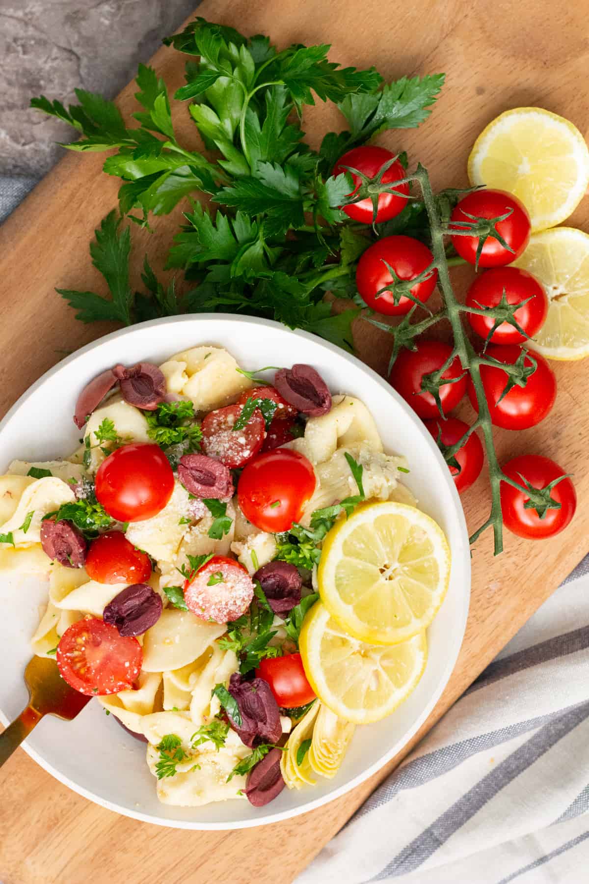 tortellini pasta salad is a delicious side for summer parties served with lemon parsley and fresh tomatoes.