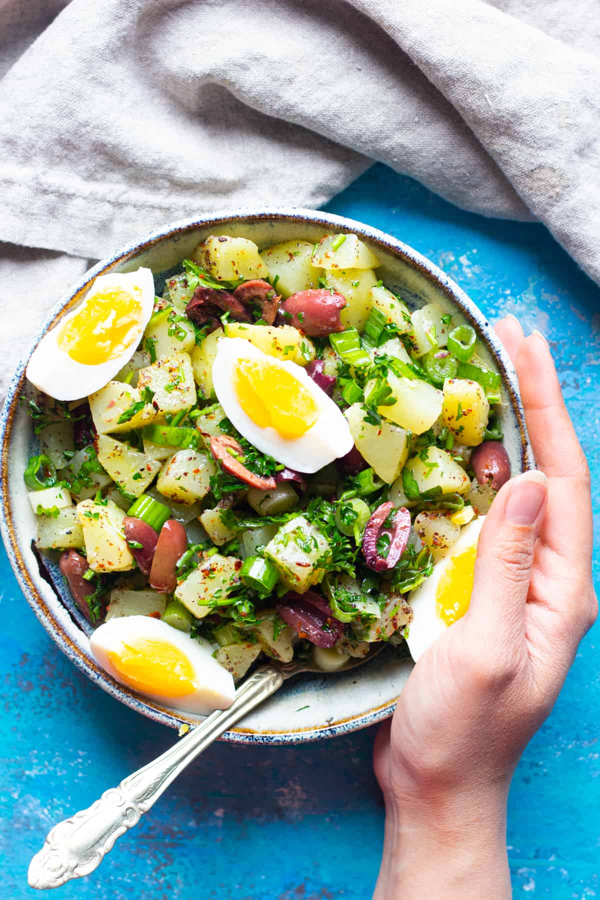 no mayo potato salad served in a bowl. It's topped with hard boiled eggs. 