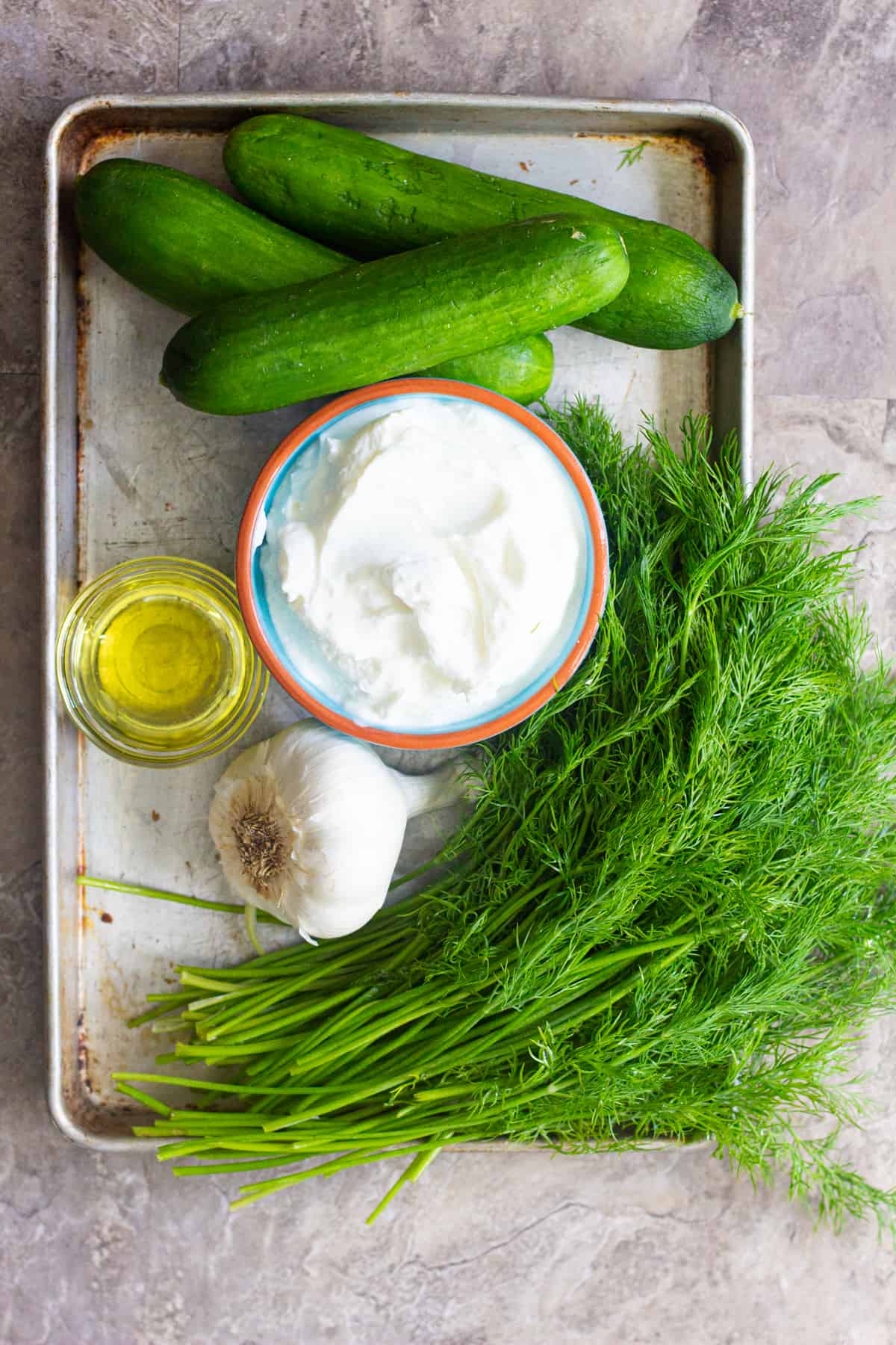 For easy tzatziki sauce you need cucumbers, yogurt, garlic, fresh dill and olive oil. 