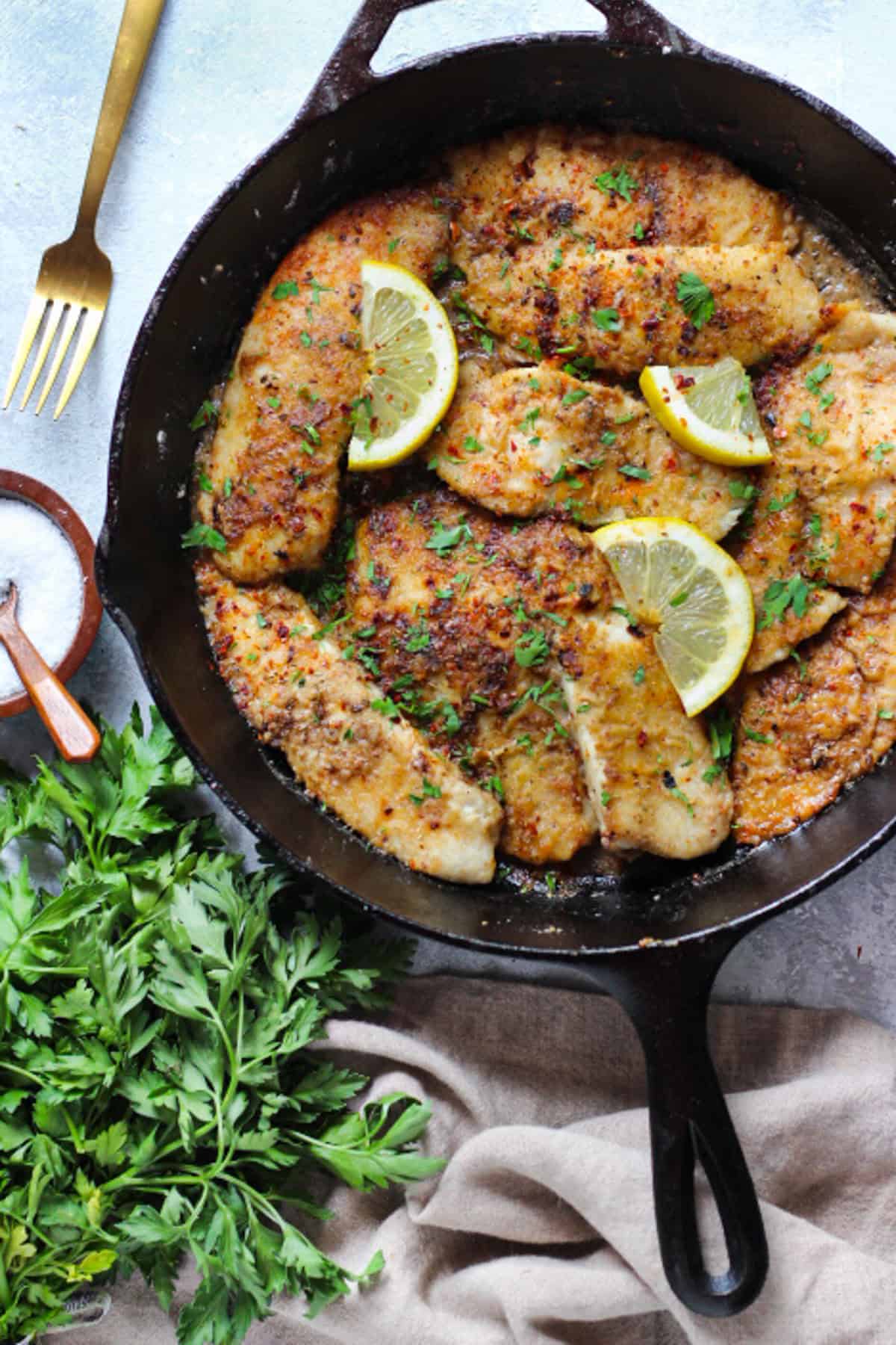 A pan of tilapia with lemon and garlic. 