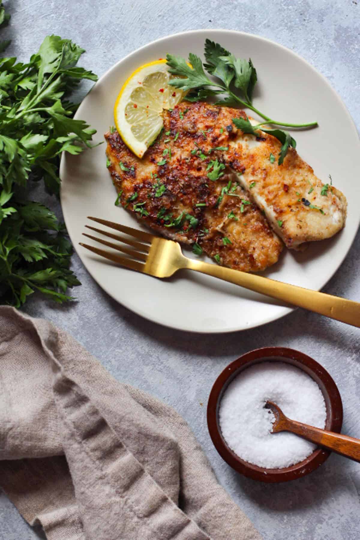 A pan of tilapia with lemon and garlic. 