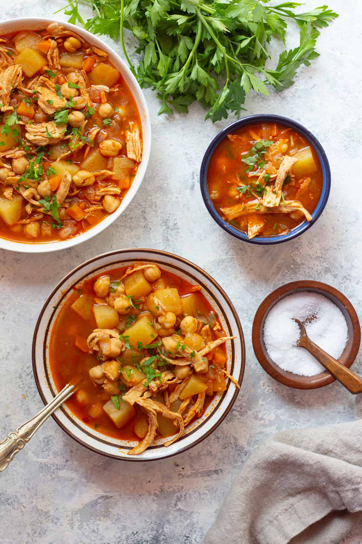 three bowls of chicken soup made with middle eastern spices. 