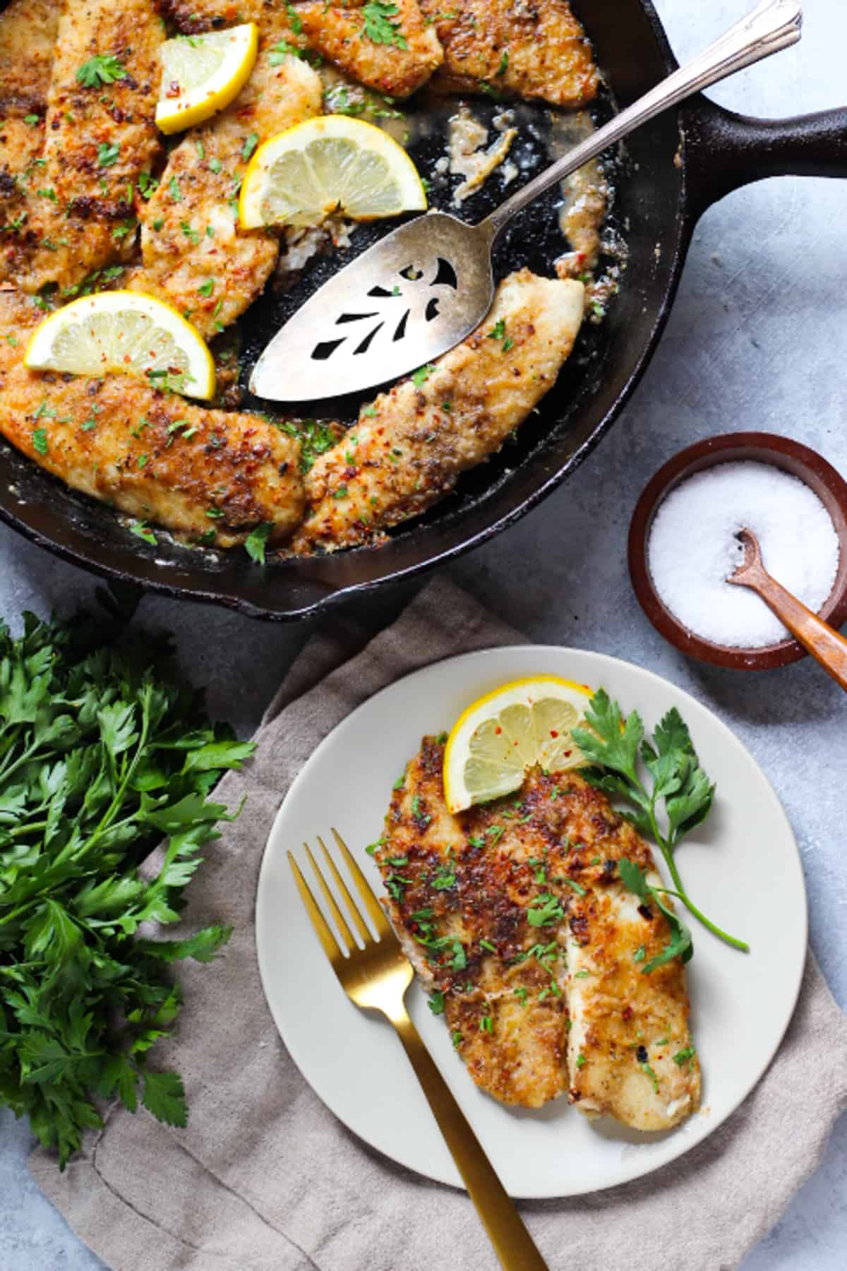 A pan of tilapia with lemon and garlic. 