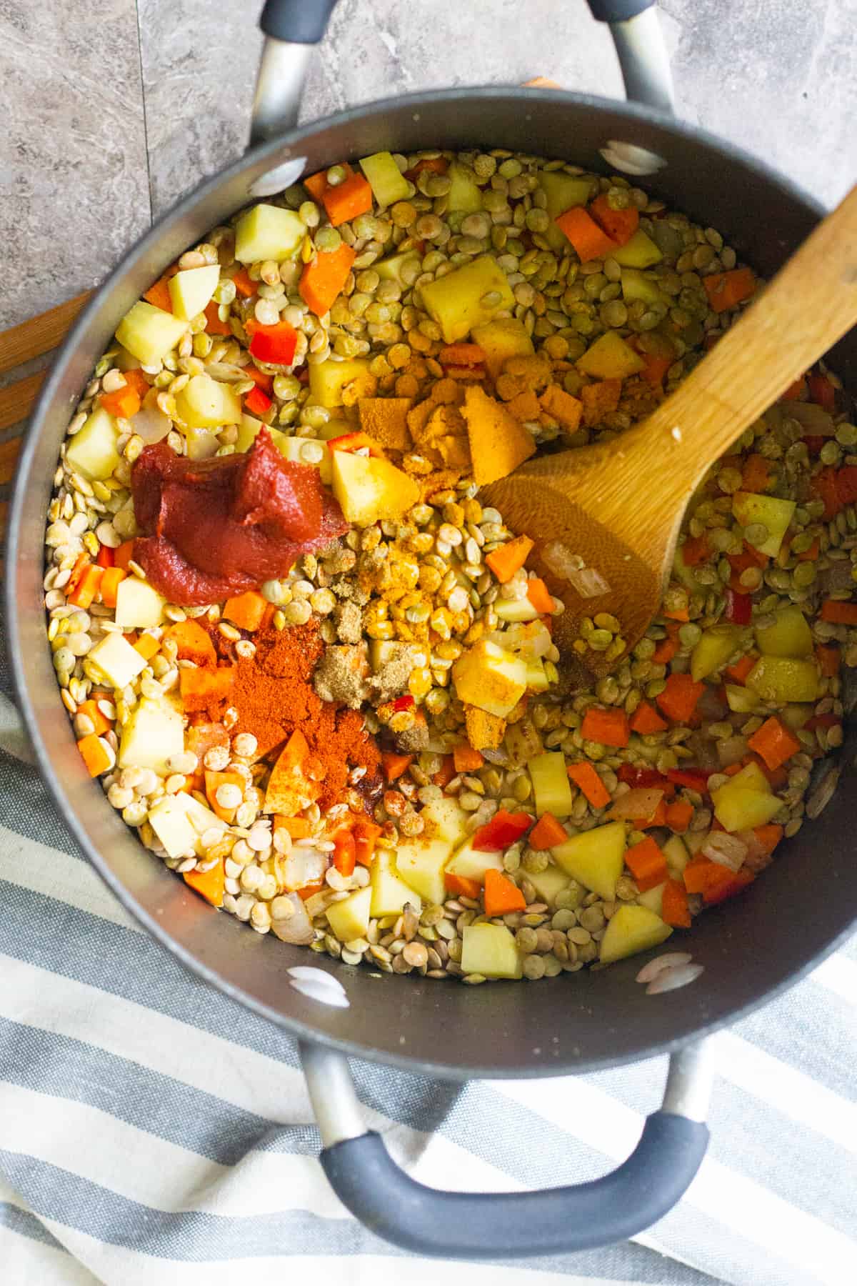 to make this simple vegetarian green lentil and spinach soup recipe saute onion and garlic, then add lentils, carrots, peppers and potatoes with spices. 