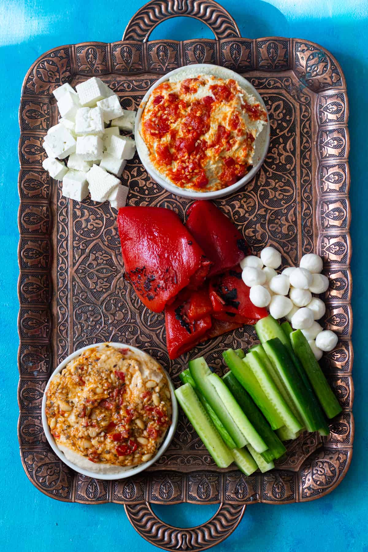 Place hummus, cucumber and cheese on the tray.