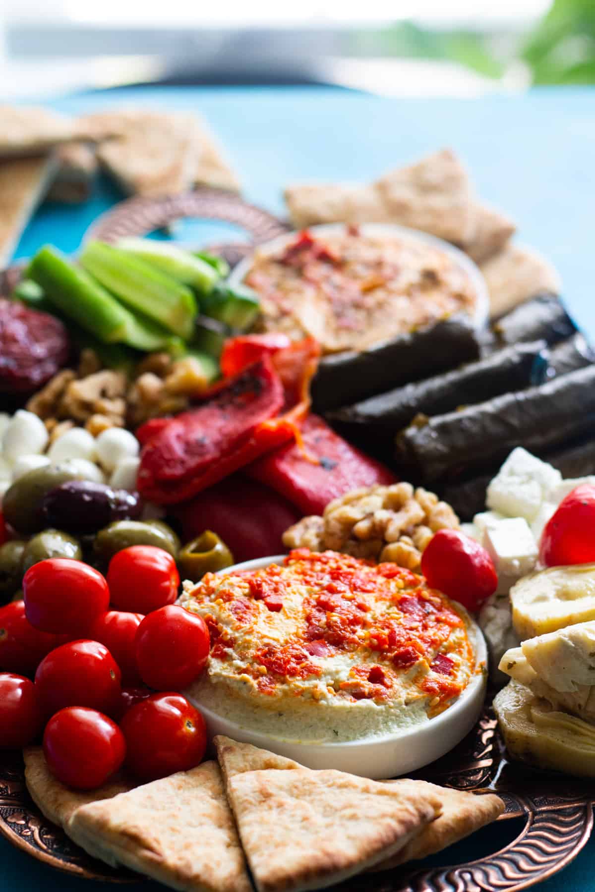 A Mediterranean platter with hummus, cheese, olives and other items.