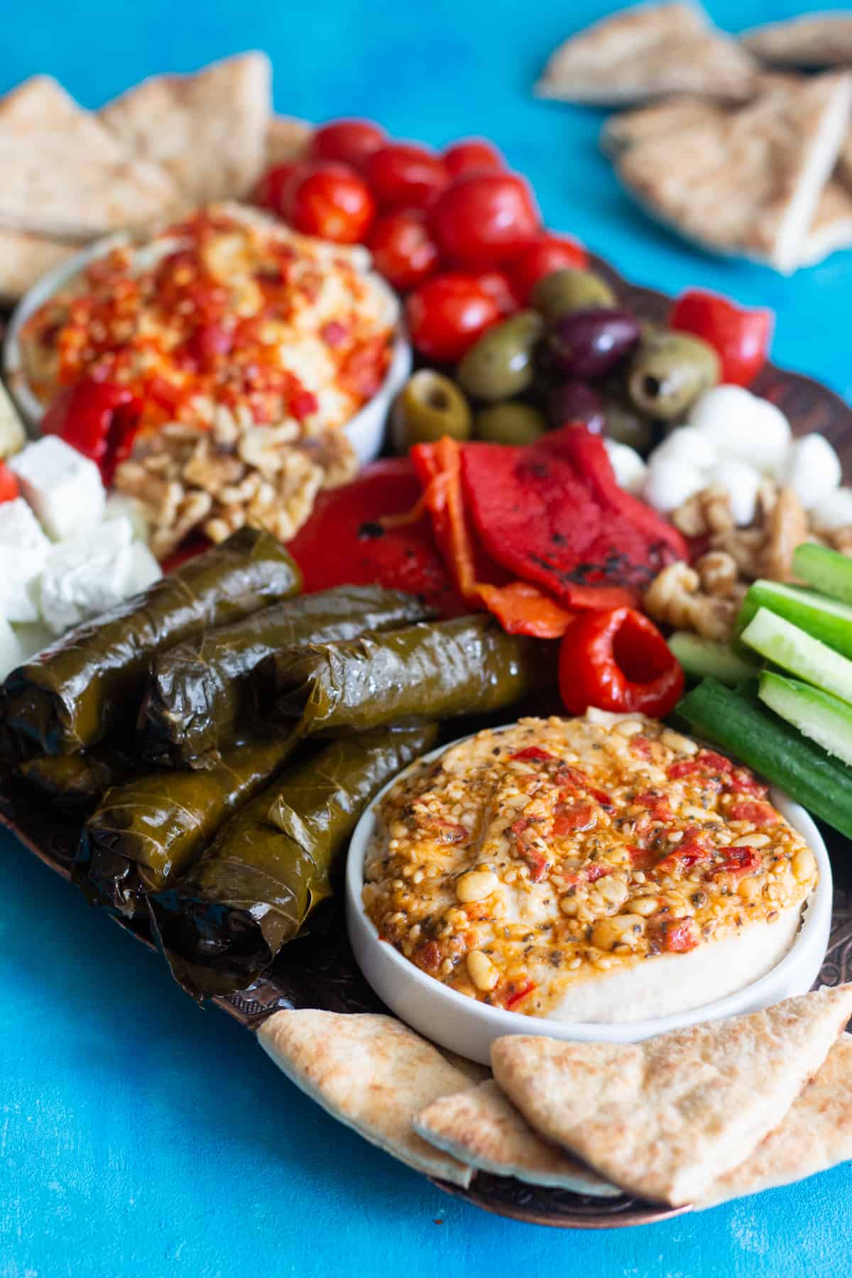 A Mediterranean platter includes hummus, roasted peppers, dolmas and cucumbers. 