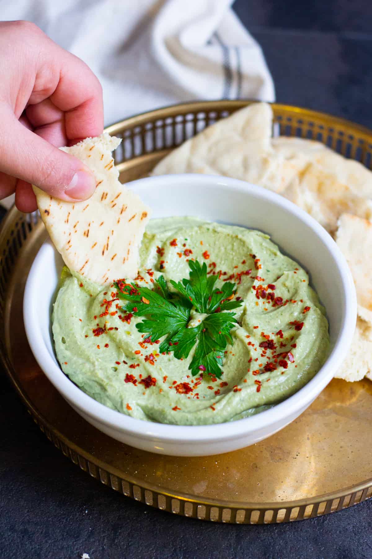 A bowl of avocado dip with pita bread. 