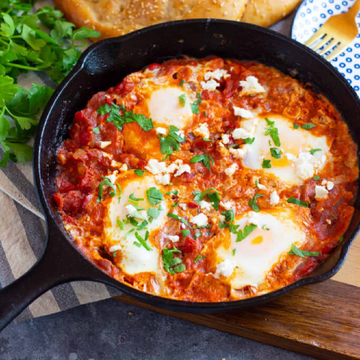 Shakshuka with feta is great for brunch. Eggs are poached in a delicious tomato sauce flavored with warm spices and vegetables and then topped with creamy feta. Learn how to make this easy one skillet breakfast recipe and enjoy it any day of the week.