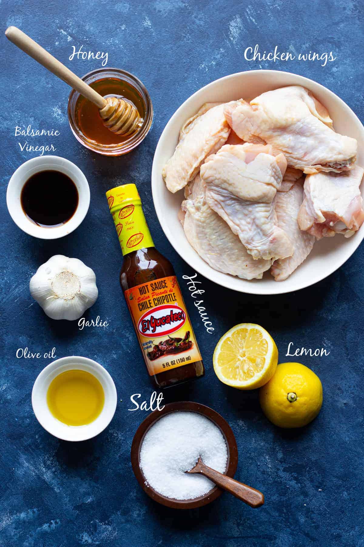 Ingredients to make grilled chicken wings are honey, balsamic, lemon, hot sauce, salt, garlic and olive oil. 