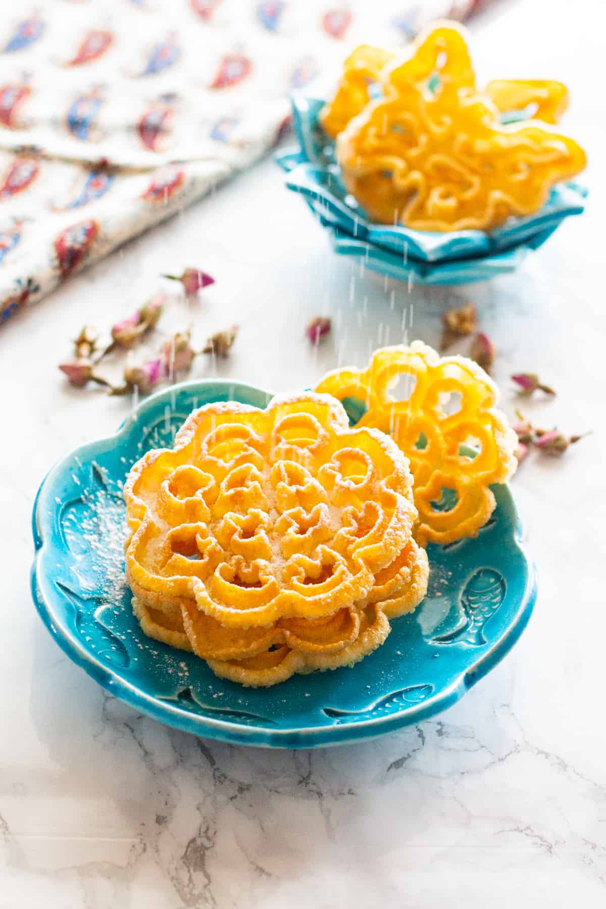 powdered sugar being dusted on Persian rosettes. 