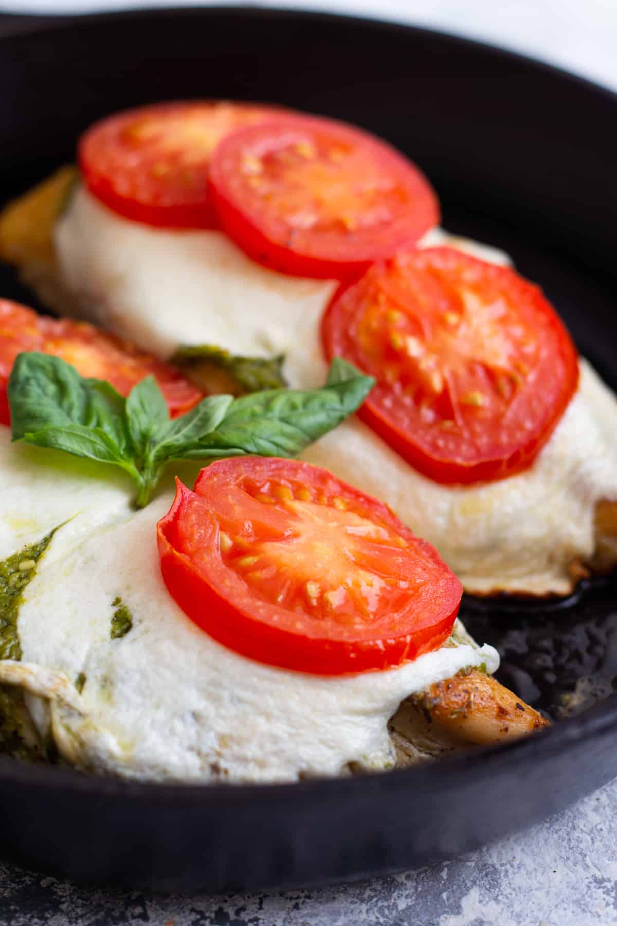 Easy caprese chicken recipe that's ready in only 30 minutes. Made with fresh tomatoes, mozzarella and pesto, this is a delicious easy weeknight dinner. Learn how to make this easy chicken recipe at home with our video and step-by-step tutorial. 
