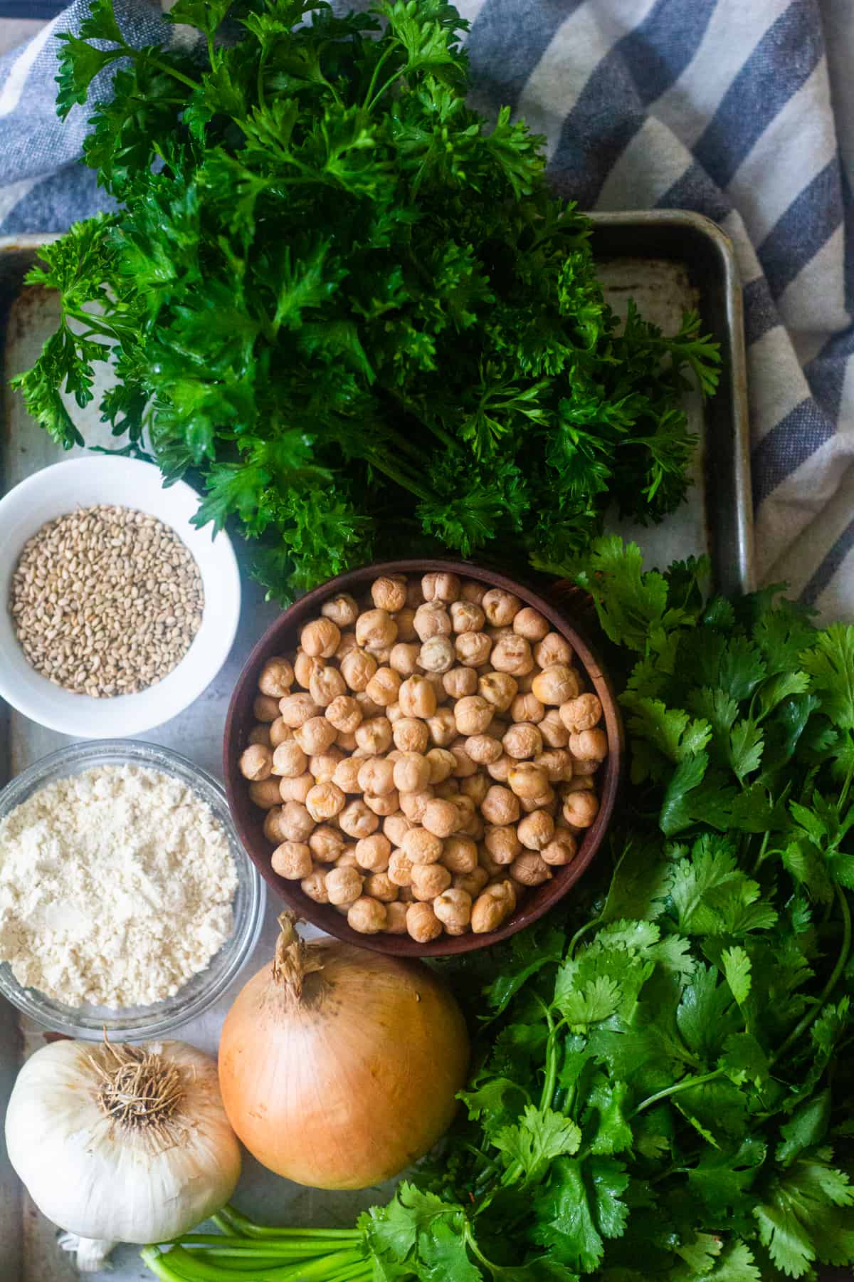 Falafel ingredients are chickpea, parsley, cilantro, onion, garlic, sesame seeds and chickpea flour. 