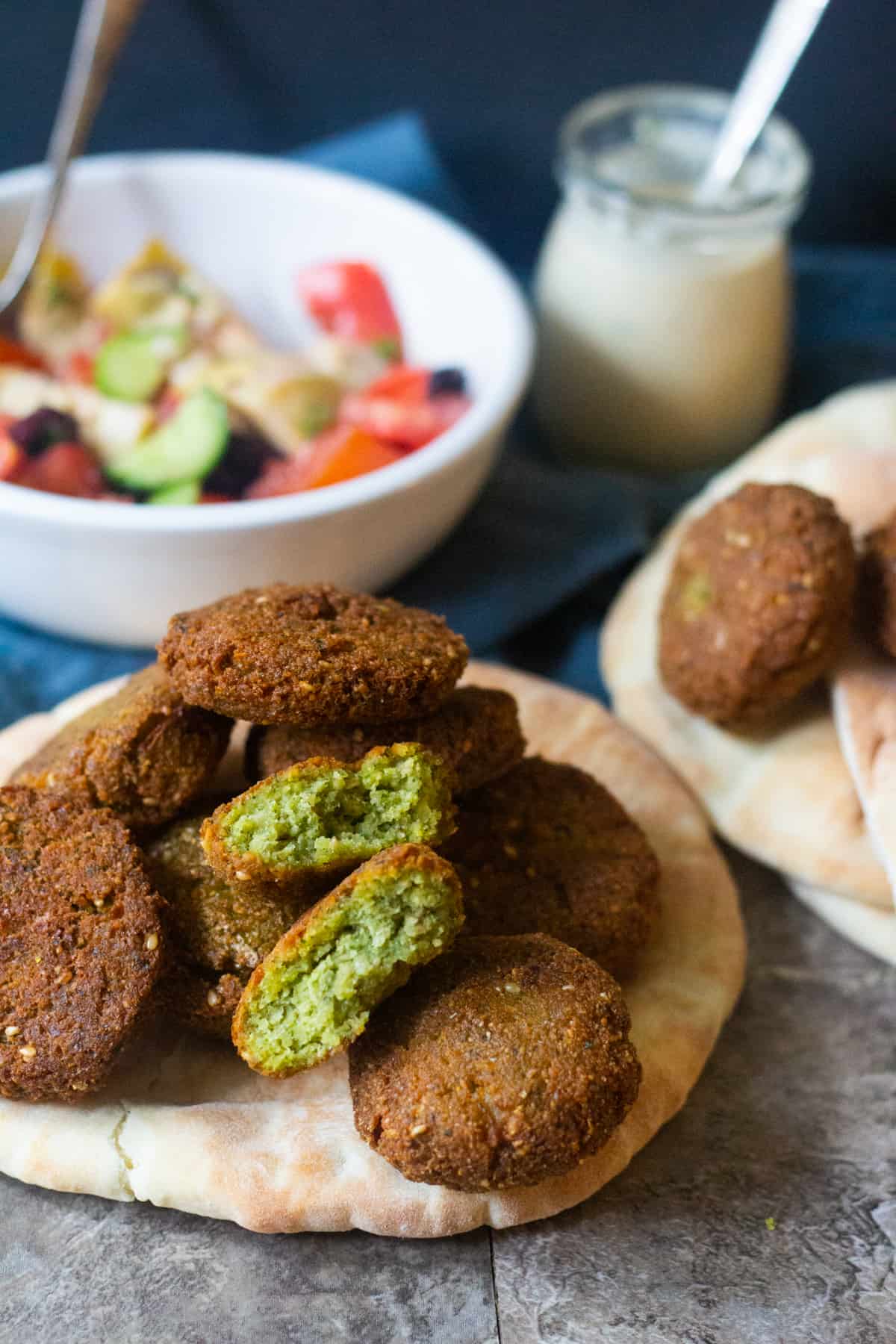 This homemade falafel recipe is easy to follow and makes delicious falafels that are crispy on the outside and soft and fluffy on the inside. Learn how to make falafels at home and ditch the take out. A few homemade falafels on a pita bread, ready to serve.